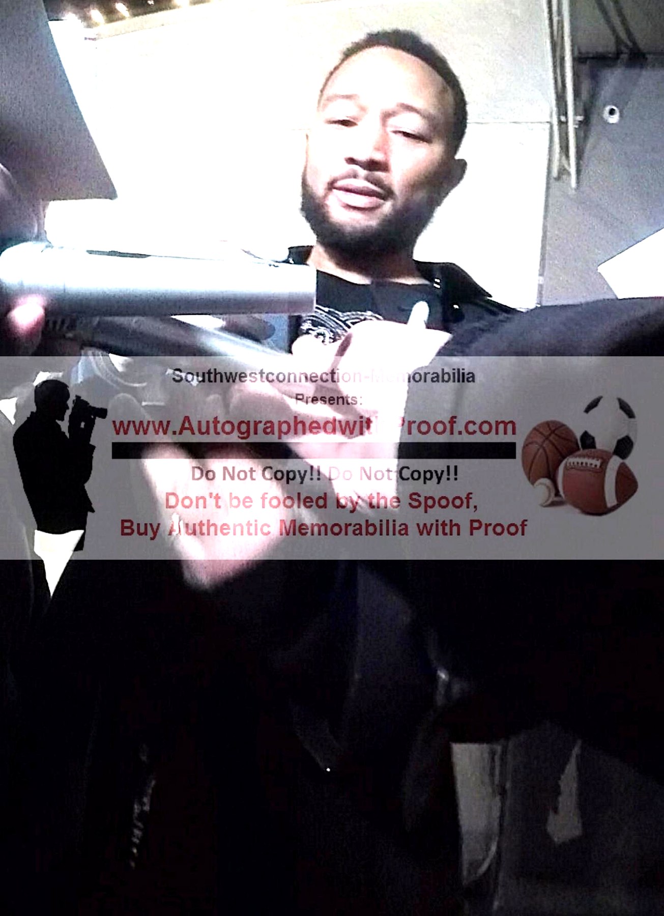 John Legend signing a microphone