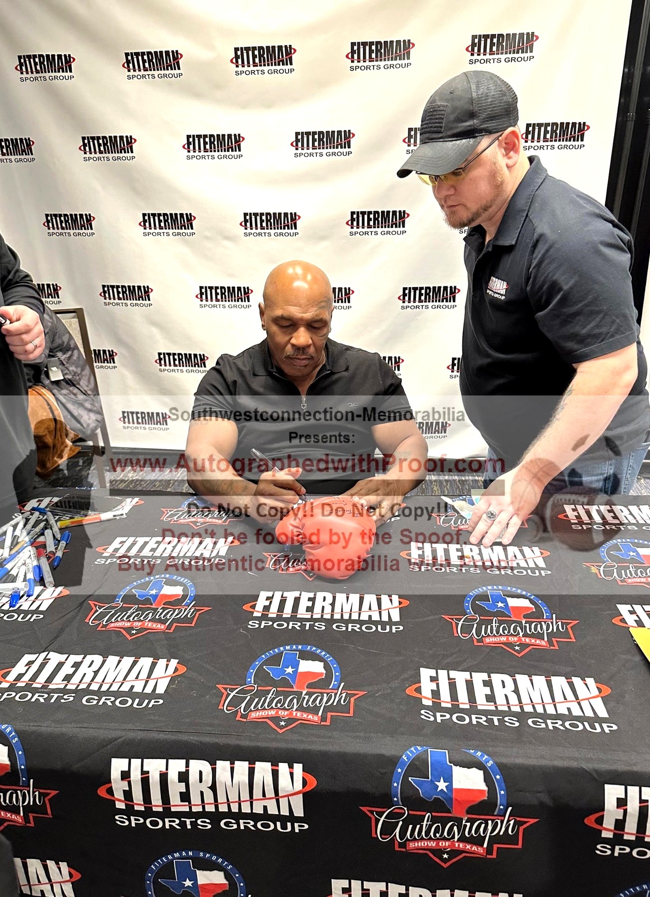 Mike Tyson signing memorabilia at an autograph event