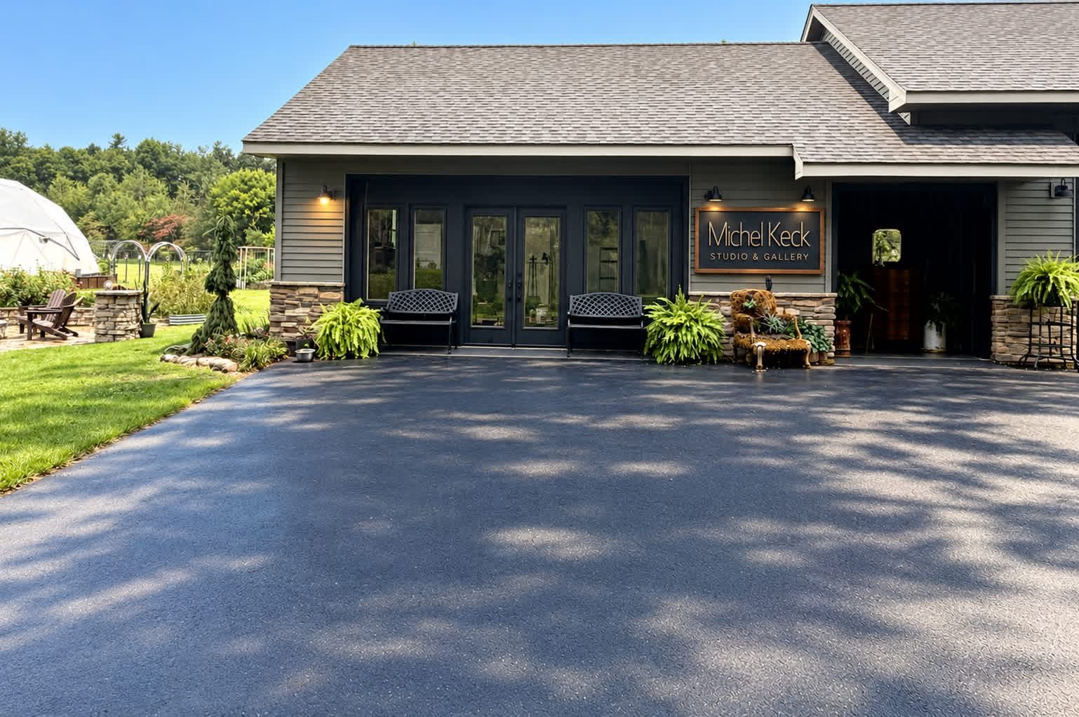 Entrance to Michel Keck Studio & Gallery in Wheatfield, Northwest Indiana, with garden plantings, benches, and a gallery sign