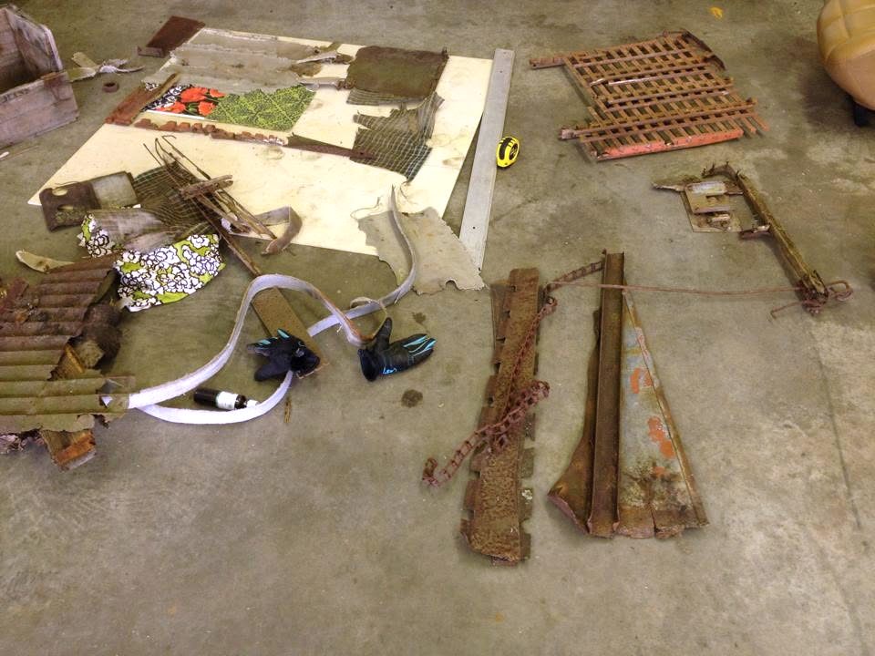 Reclaimed wood and rusted metal laid out before becoming found-object art