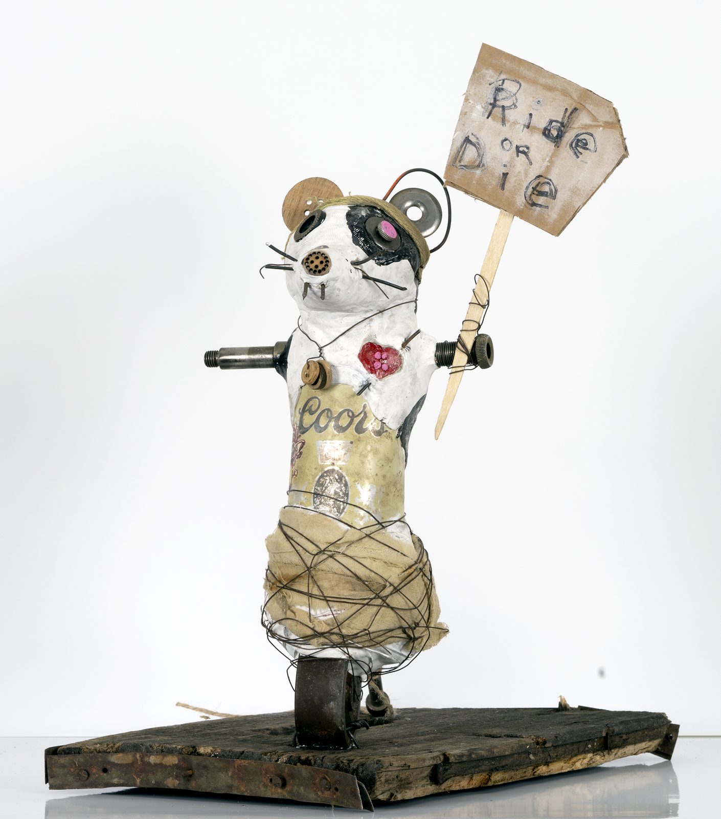 Ride or Die, a found-object rat sculpture holding a handmade sign