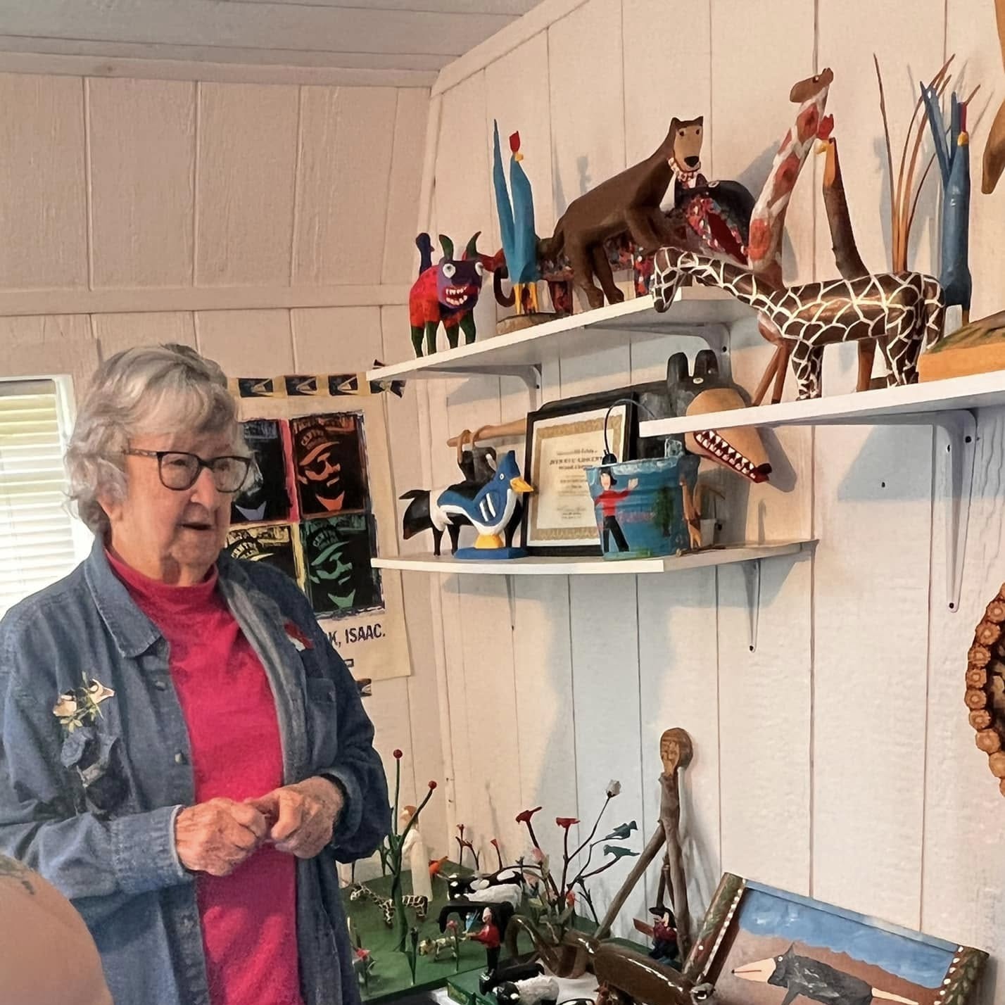 A visit inside Minnie Adkins’ personal gallery, surrounded by colorful carved animals and folk art on shelves