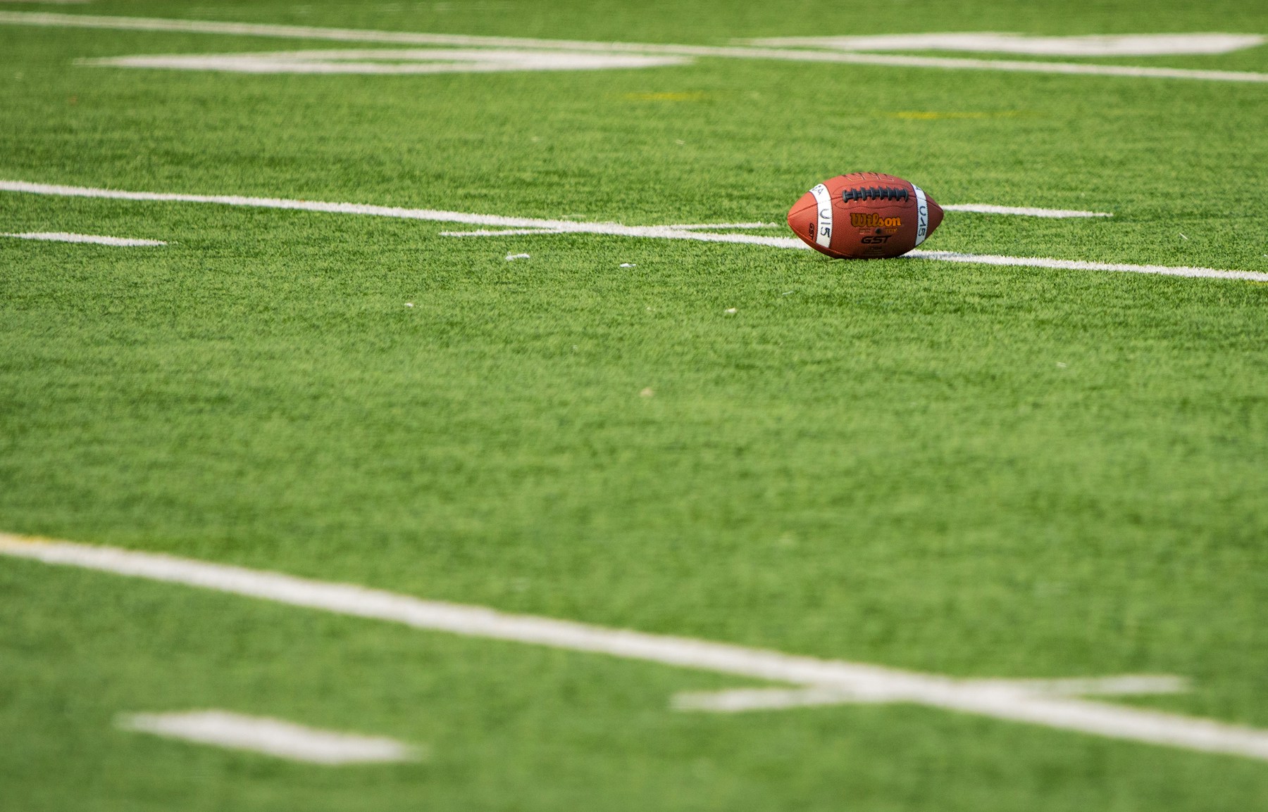 Football resting beside a white yard line