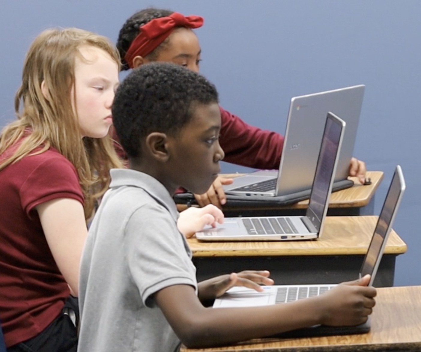 J.W. Reed Christian Academy students learning with laptops in the classroom