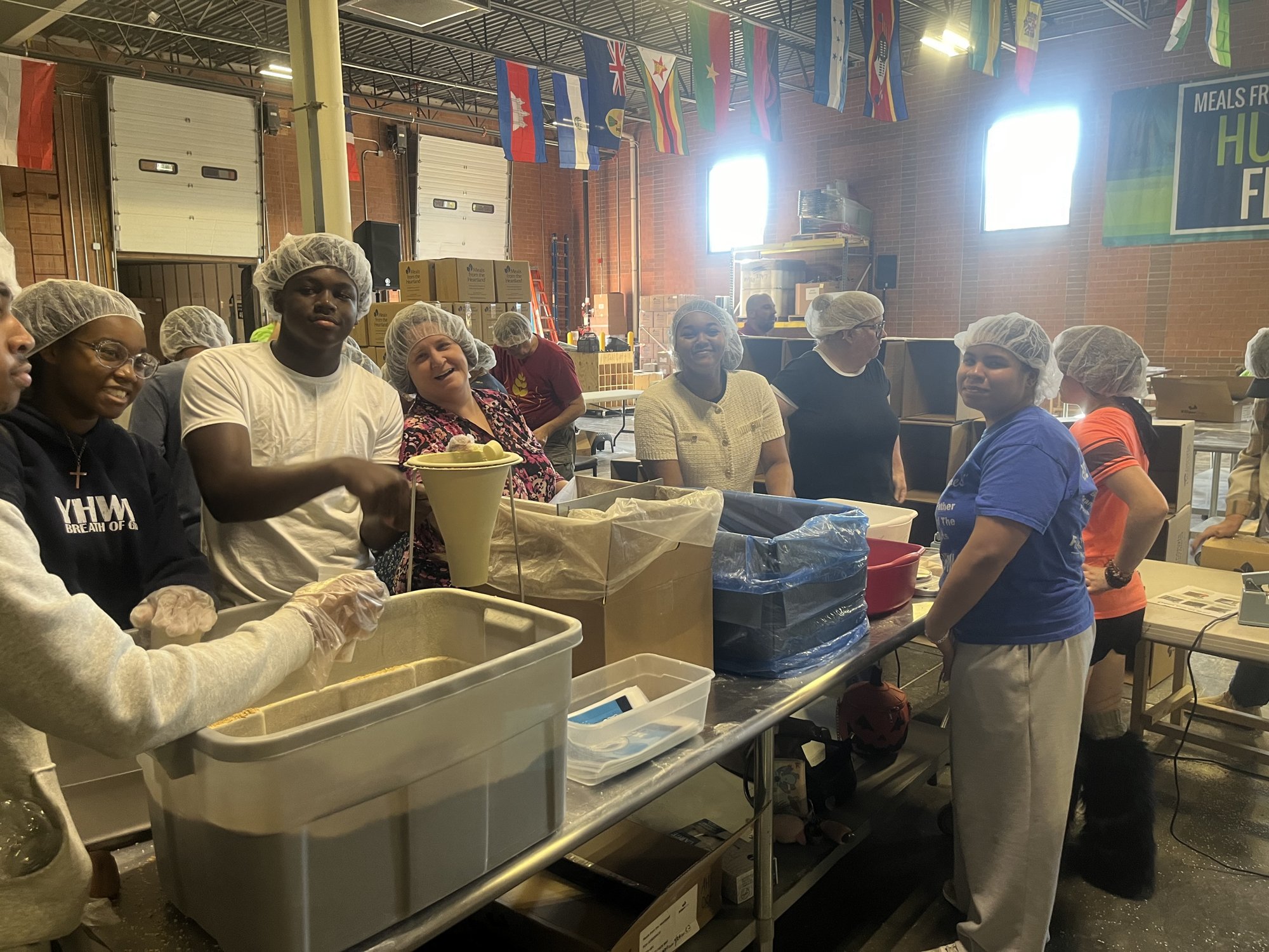 JWRCA students, Administrator Tara Ross, and volunteers packaging meals at Meals from the Heartland