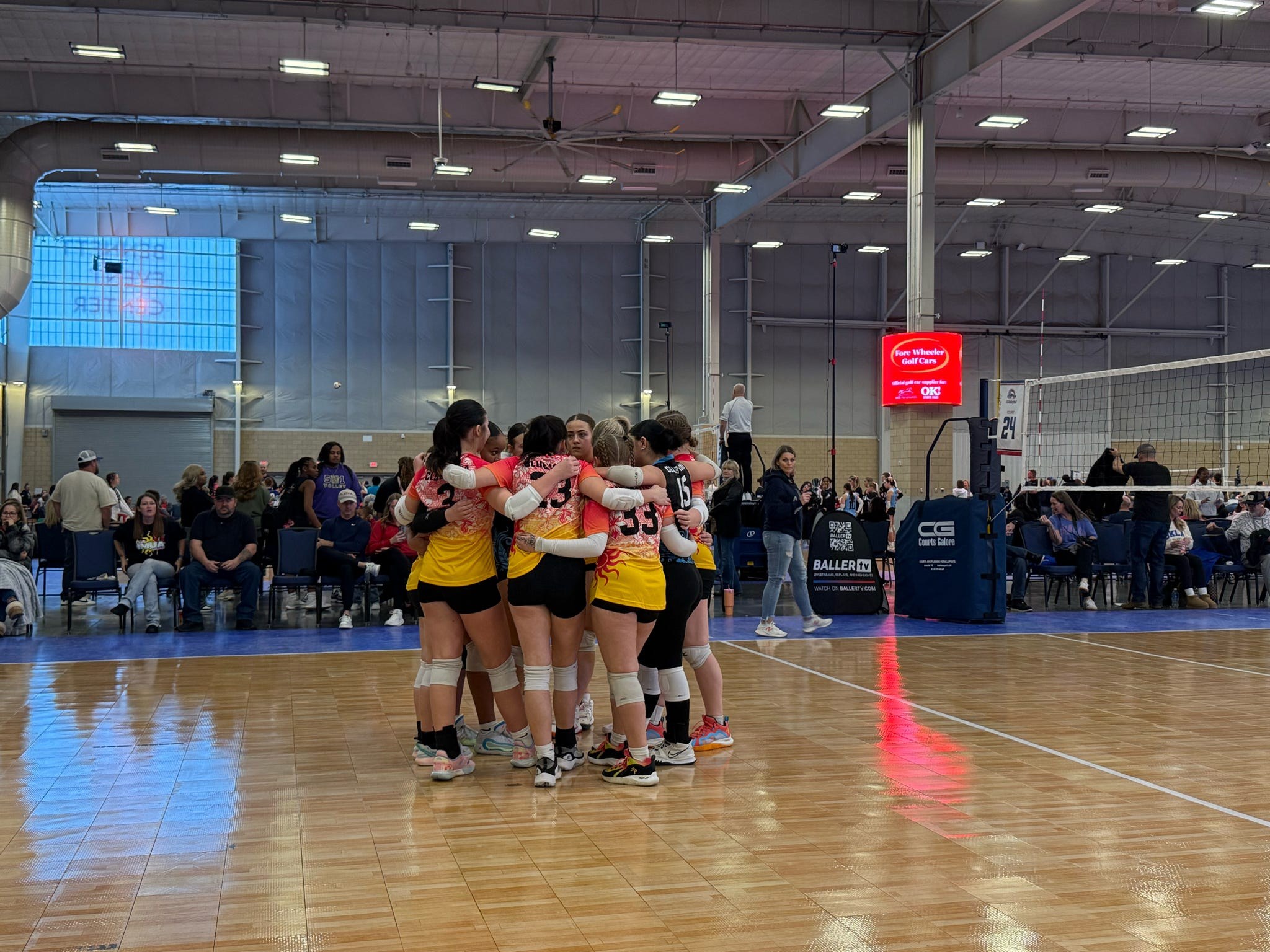 Club IMUA Volleyball athletes huddled together on the court