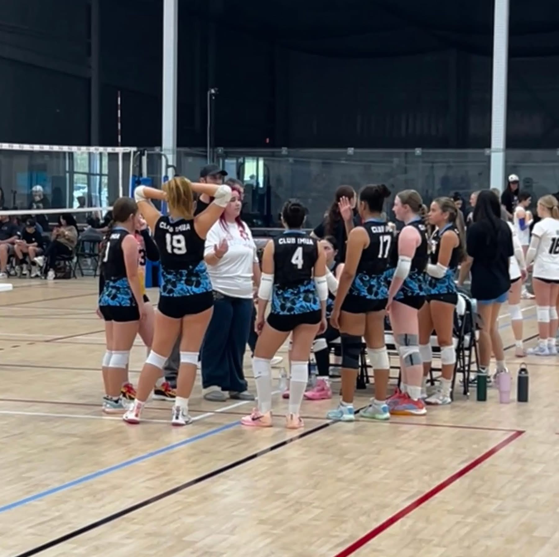 Club IMUA Volleyball athletes gathered in a supportive team huddle
