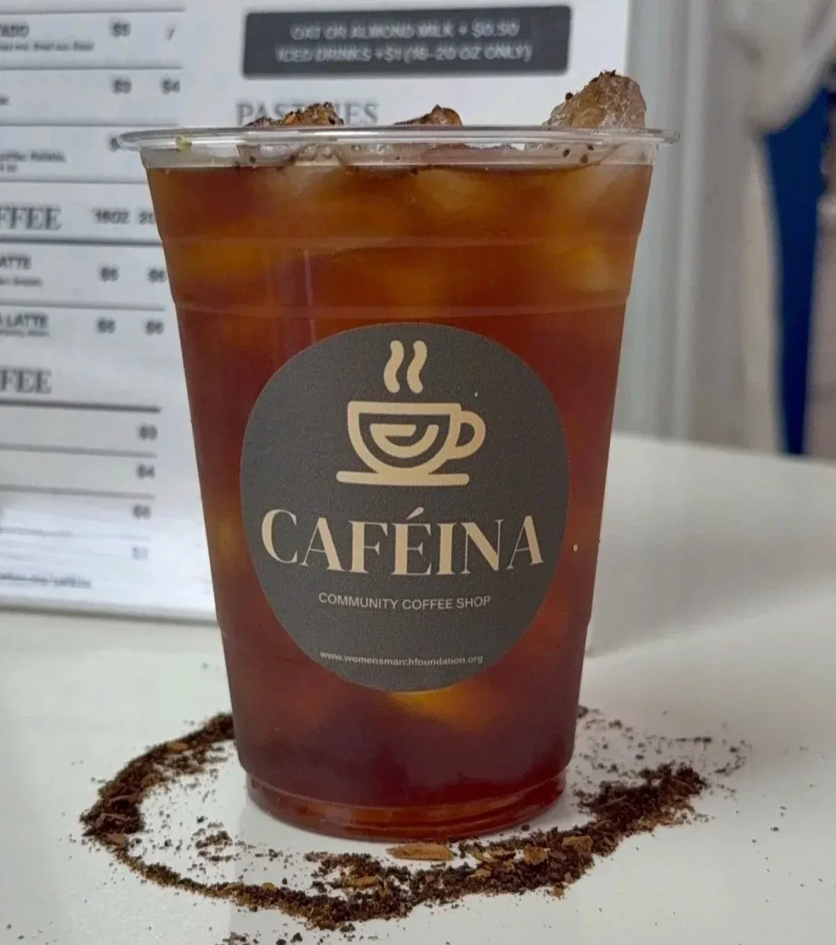 A glass of Caféina café de olla with a cinnamon stick