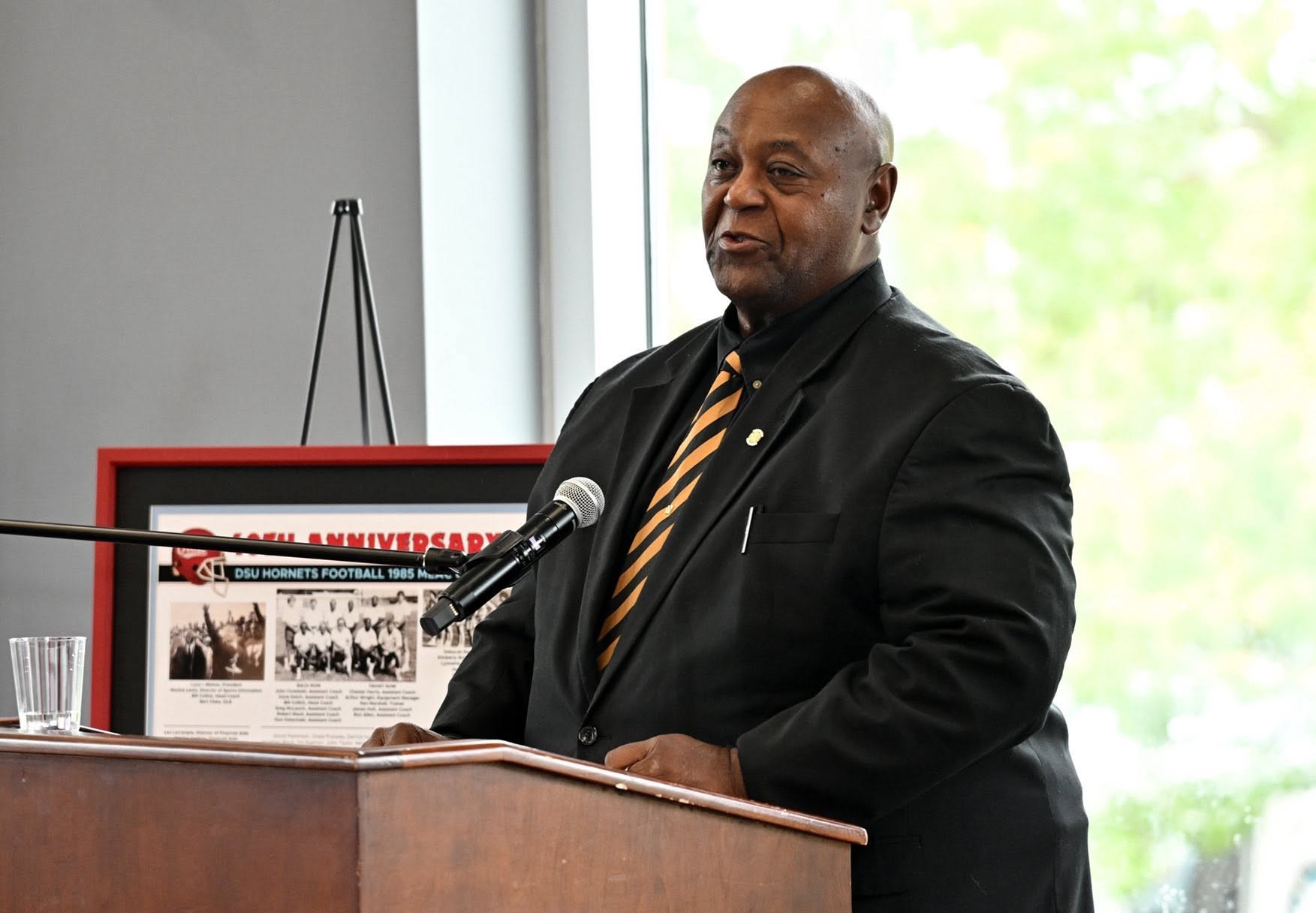 Grandmaster Kemmerlin speaking at a lectern during the 1985 MEAC Championship team reunion at Delaware State University