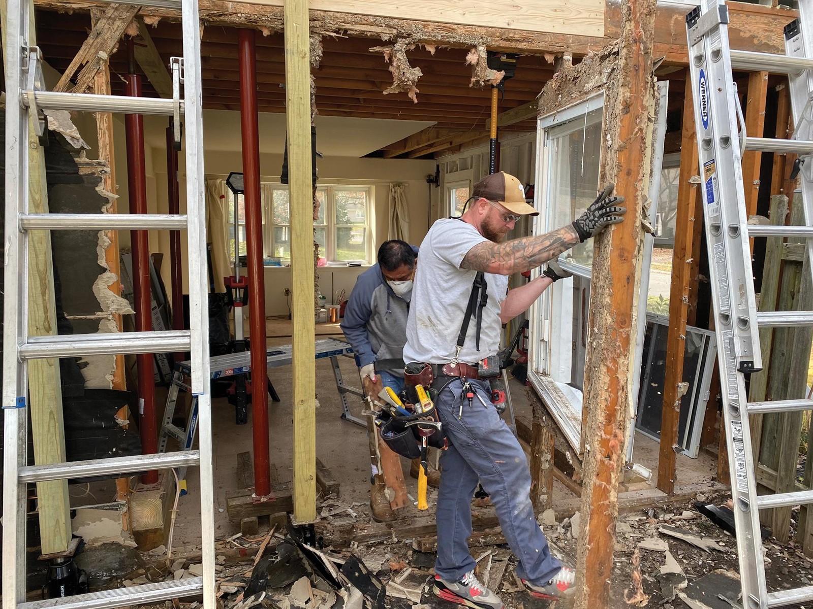 Workers renovating a home with exposed framing