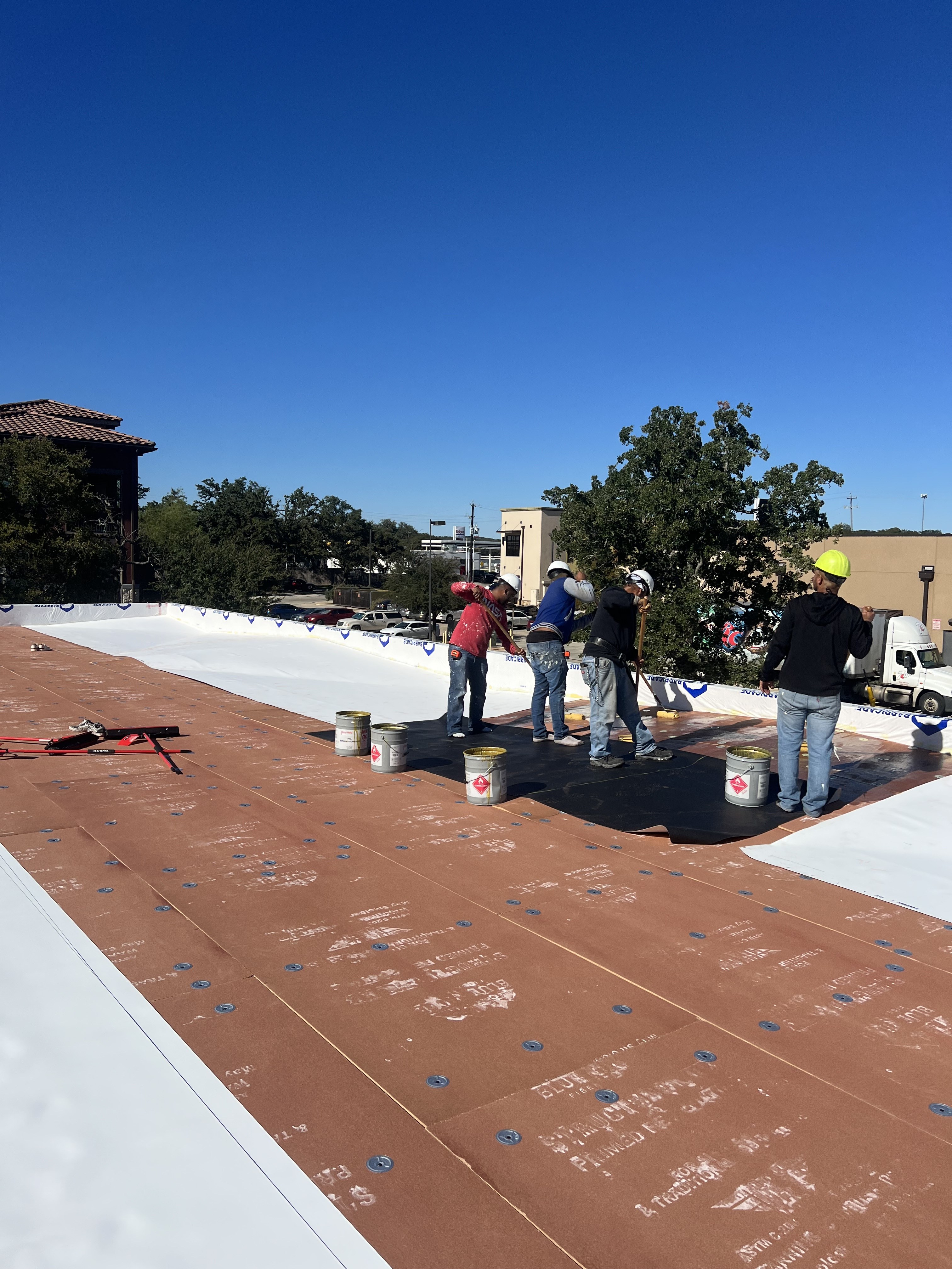 Commercial roofing crew working on a membrane system