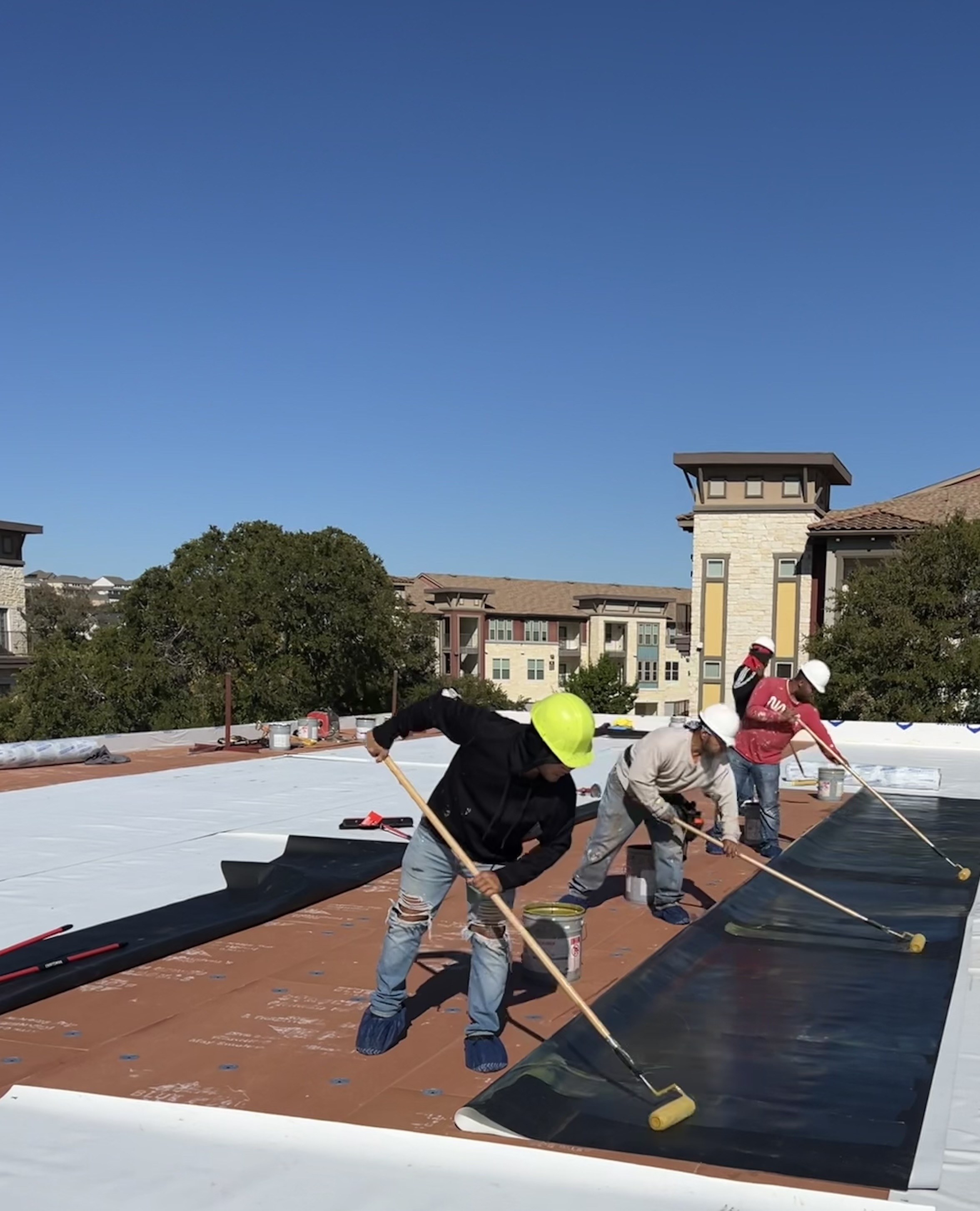 Roofing crew installing a commercial membrane roof