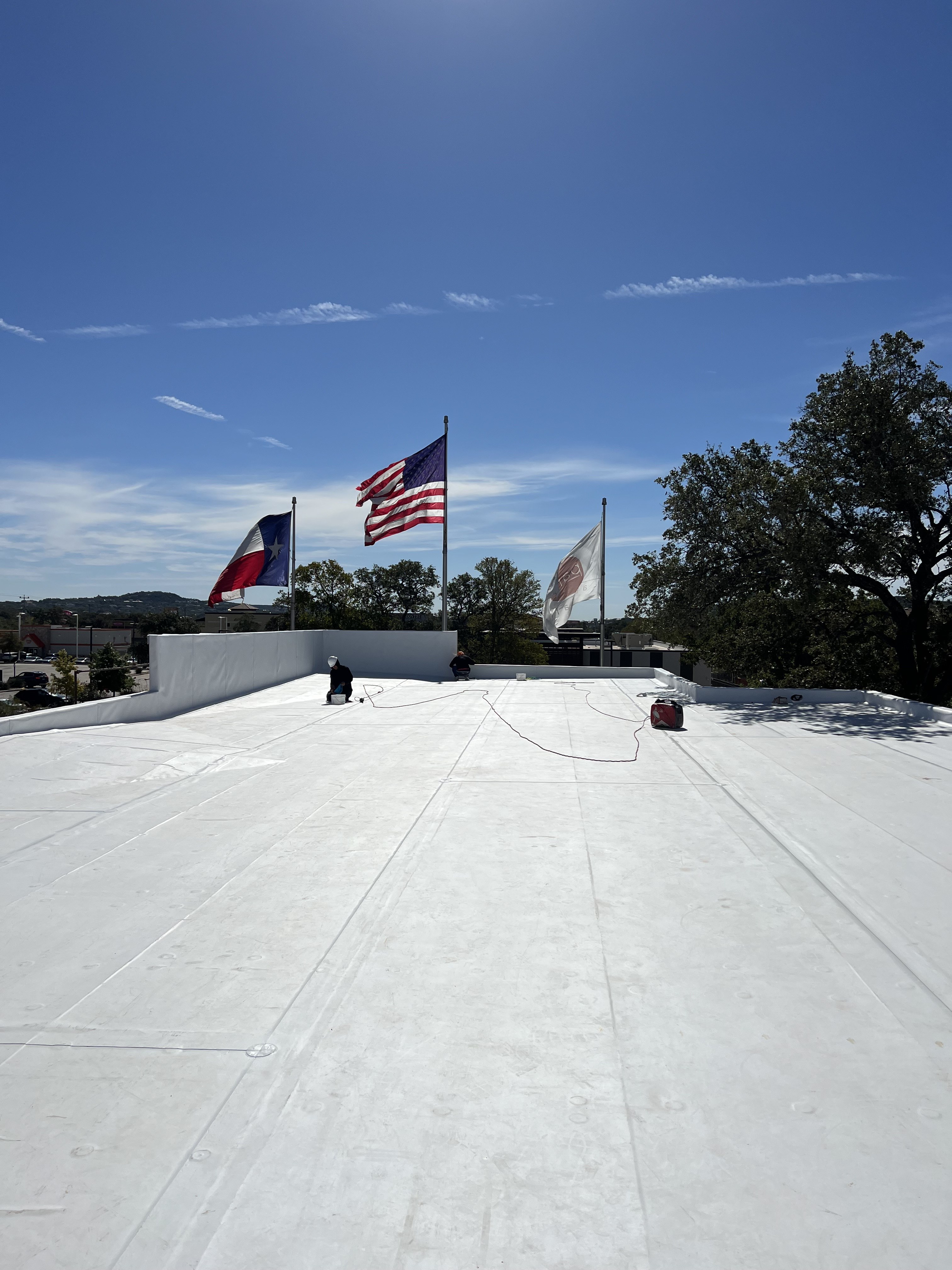 Completed commercial roof membrane beside flagpoles