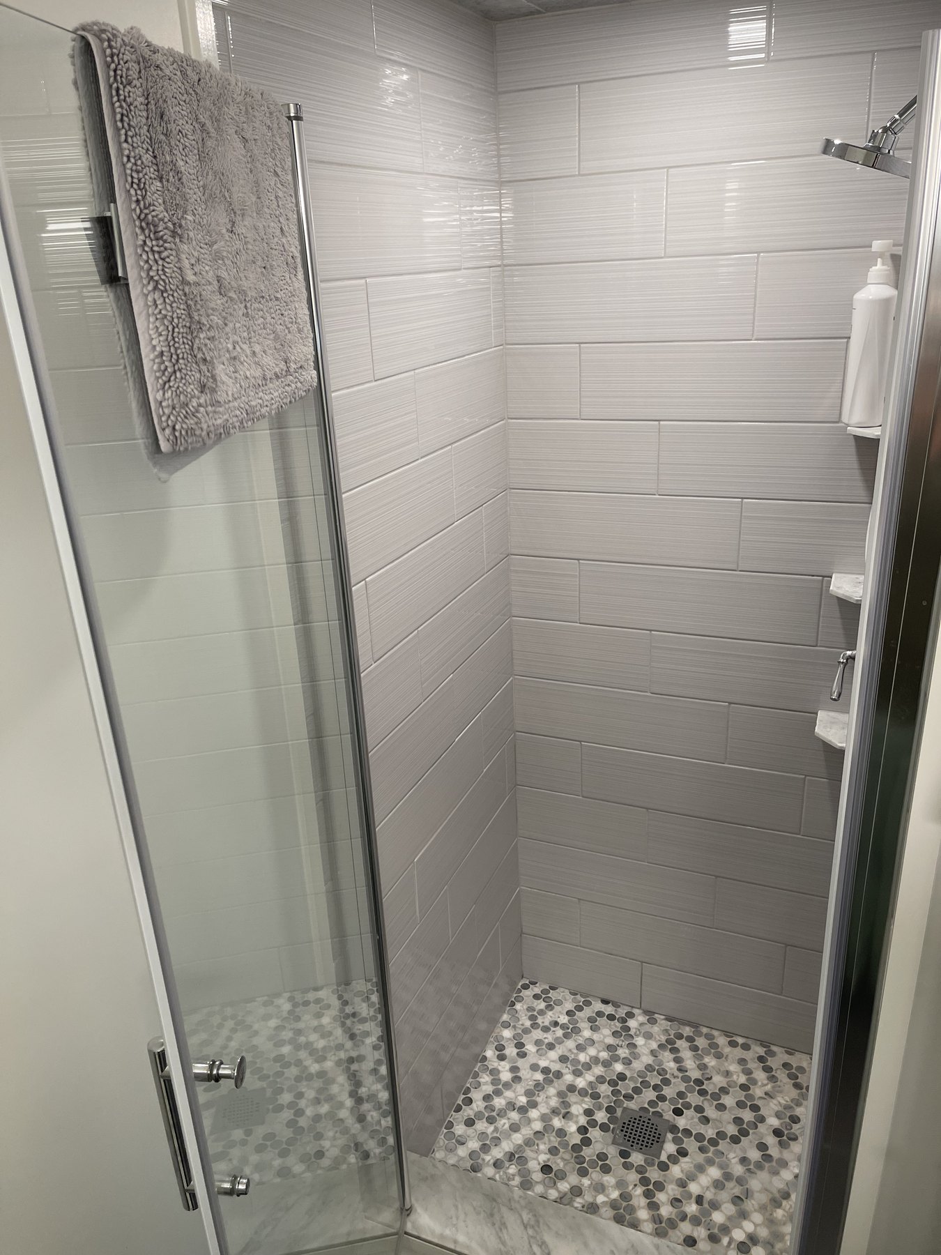 Walk-in shower with tiled walls and pebble floor