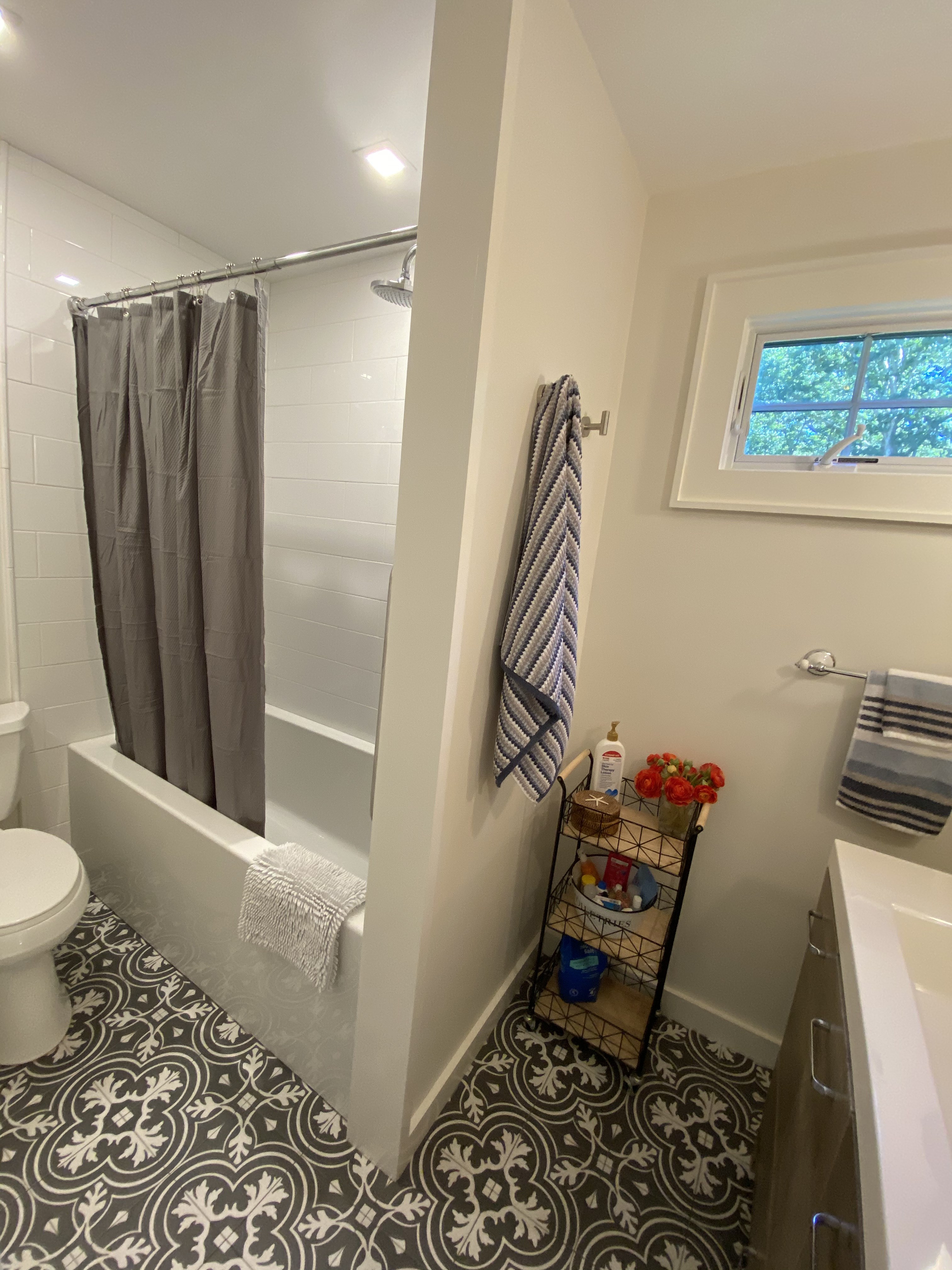 Bathroom with tub, vanity, and patterned tile floor