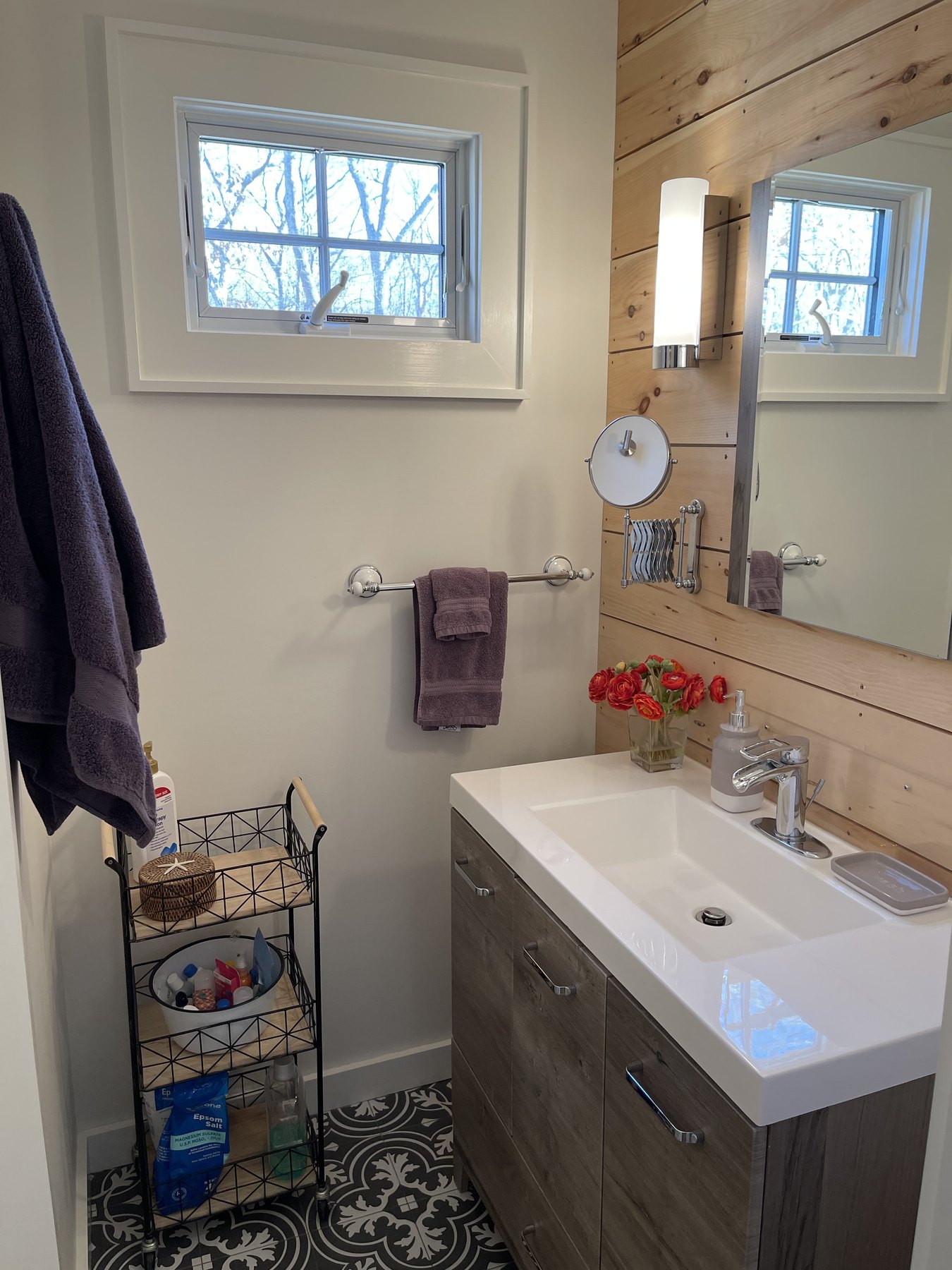 En-suite bathroom vanity with mirror, fresh towels, and flowers