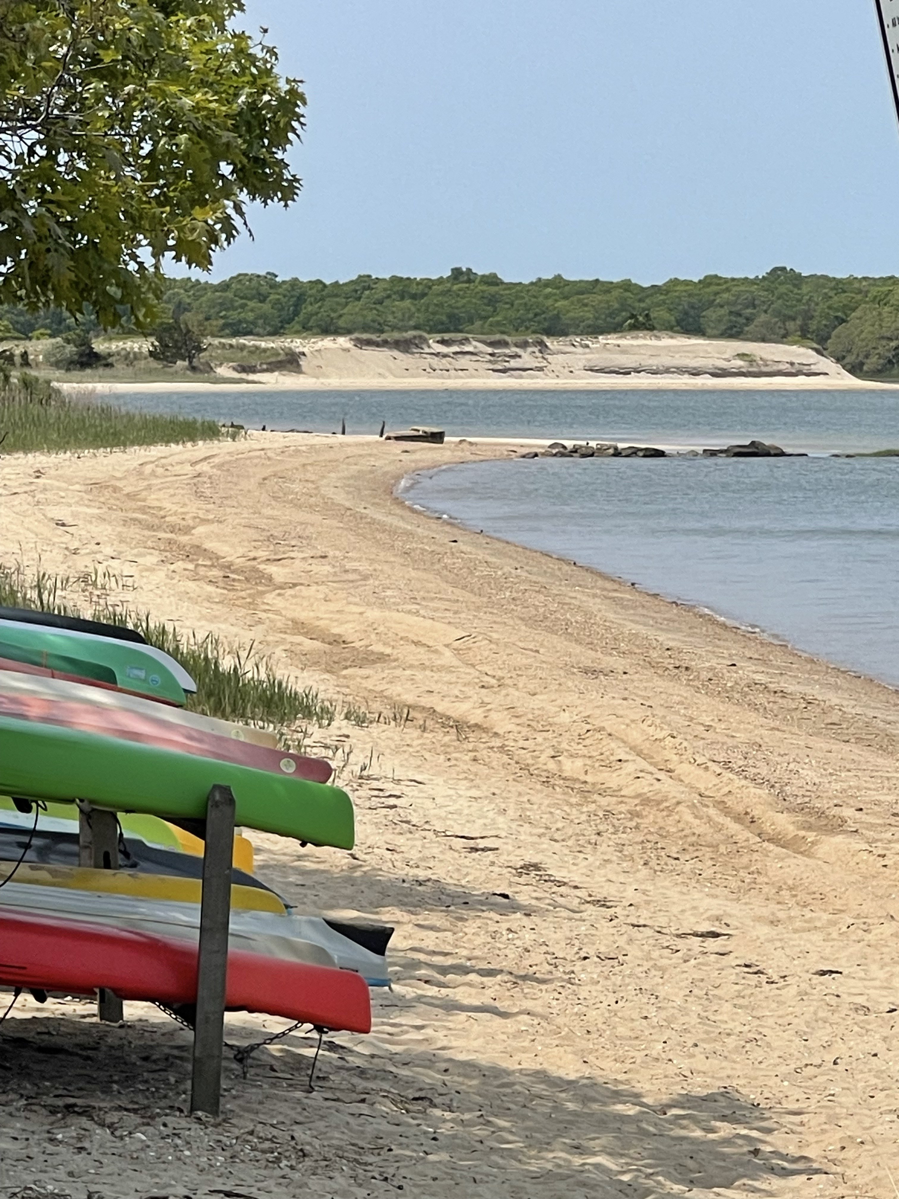 Colorful kayaks beside a sandy East Hampton beach