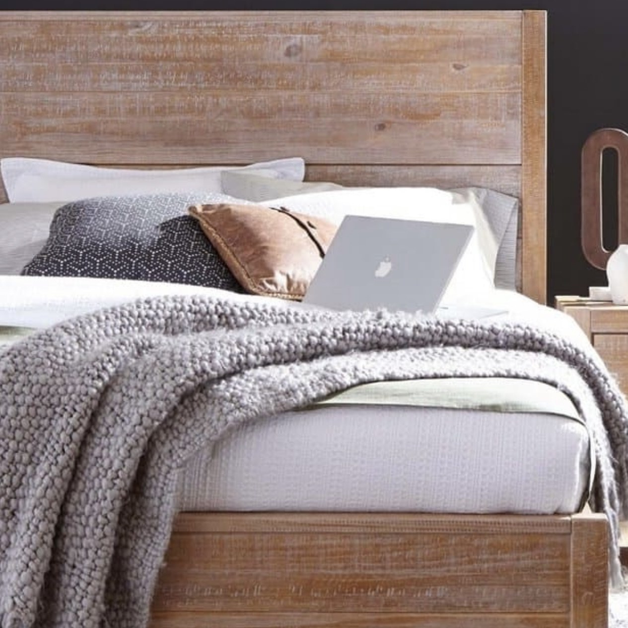 King bed with cozy layers and a laptop ready for a relaxed stay