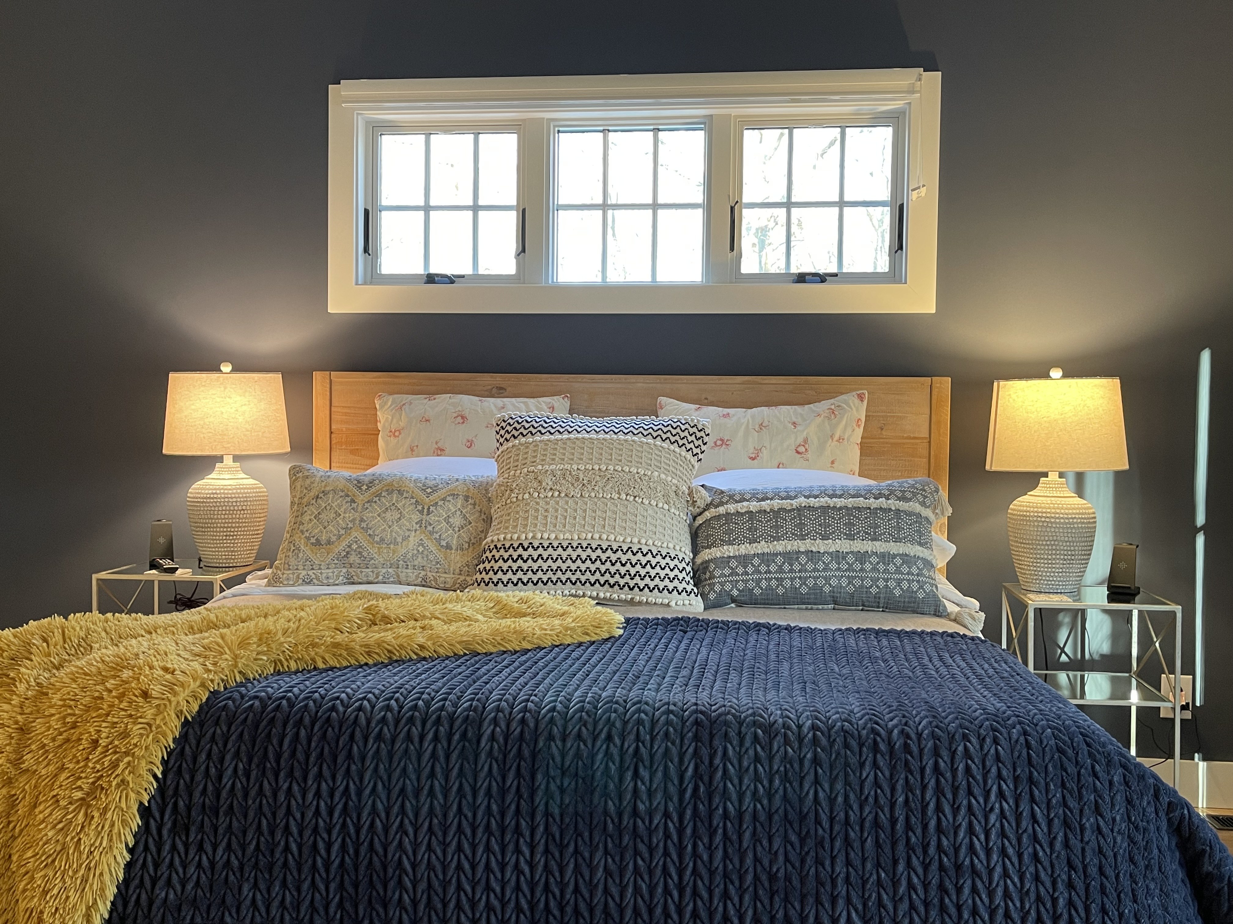 King bed with deep blue coverlet in the suite