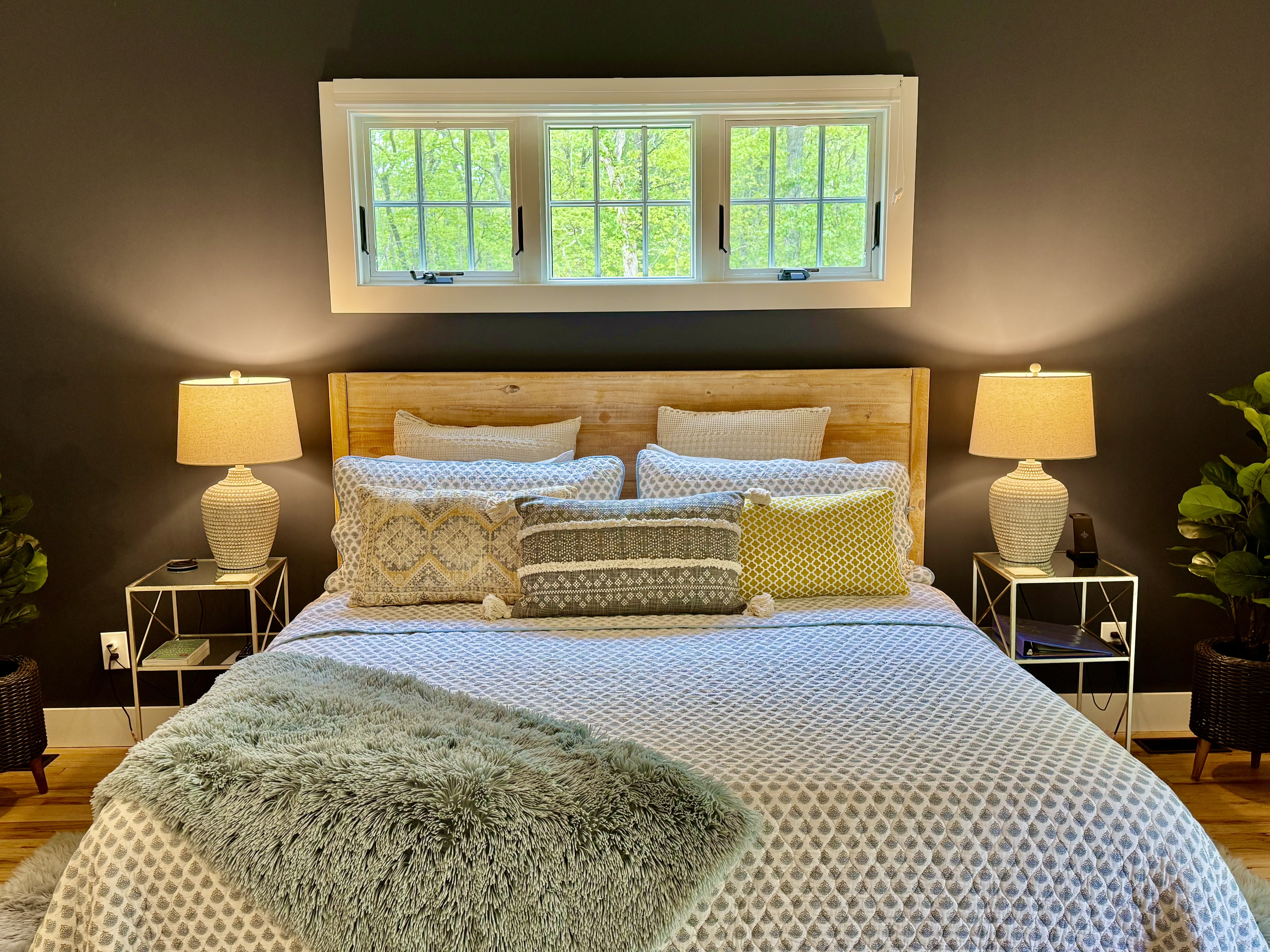 King bed framed by soft lighting and a view of the trees