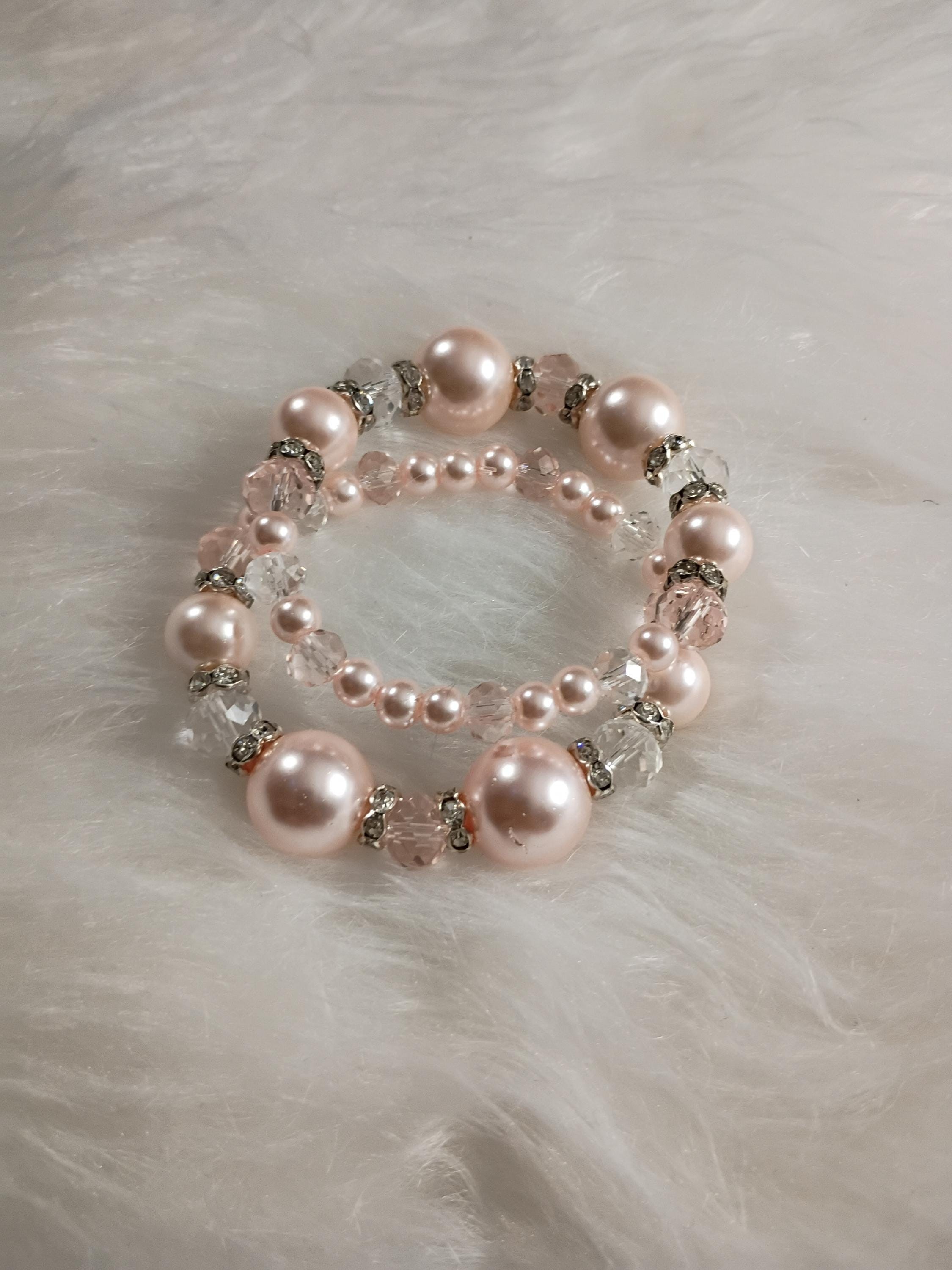 Indulge in the elegance of soft pink pearls paired with the brilliance of crystal glass beads.