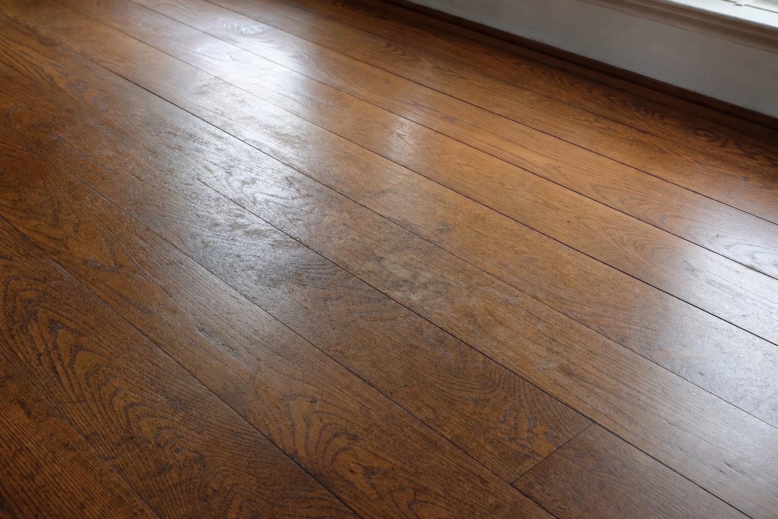 Older oak floor with a dulled worn finish in a high-traffic area