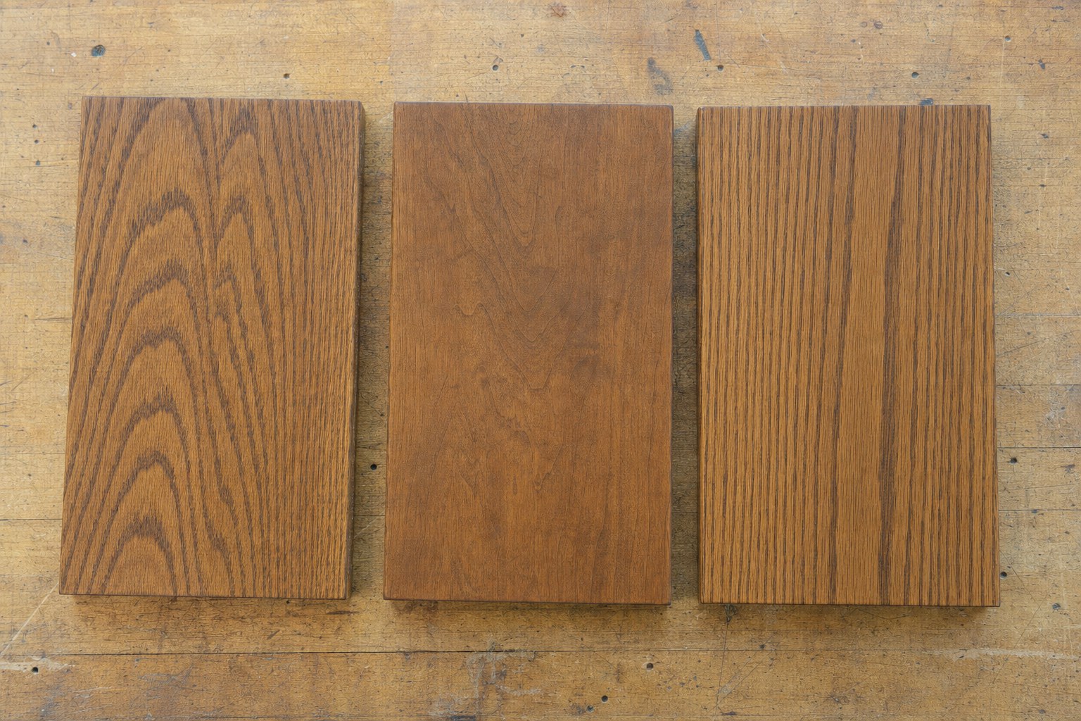 Three stained wood sample boards showing different grain patterns