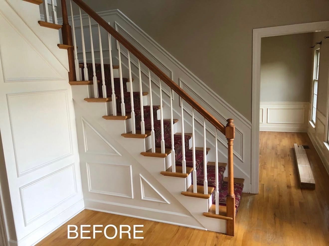 Before: wood staircase with white turned balusters and traditional rail