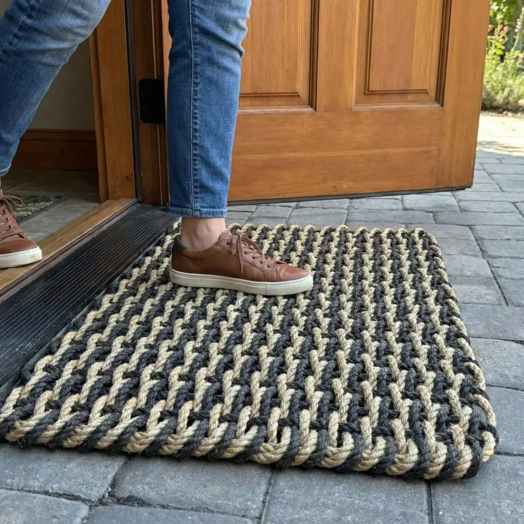 Detail of a dense black and tan double-weave rope doormat
