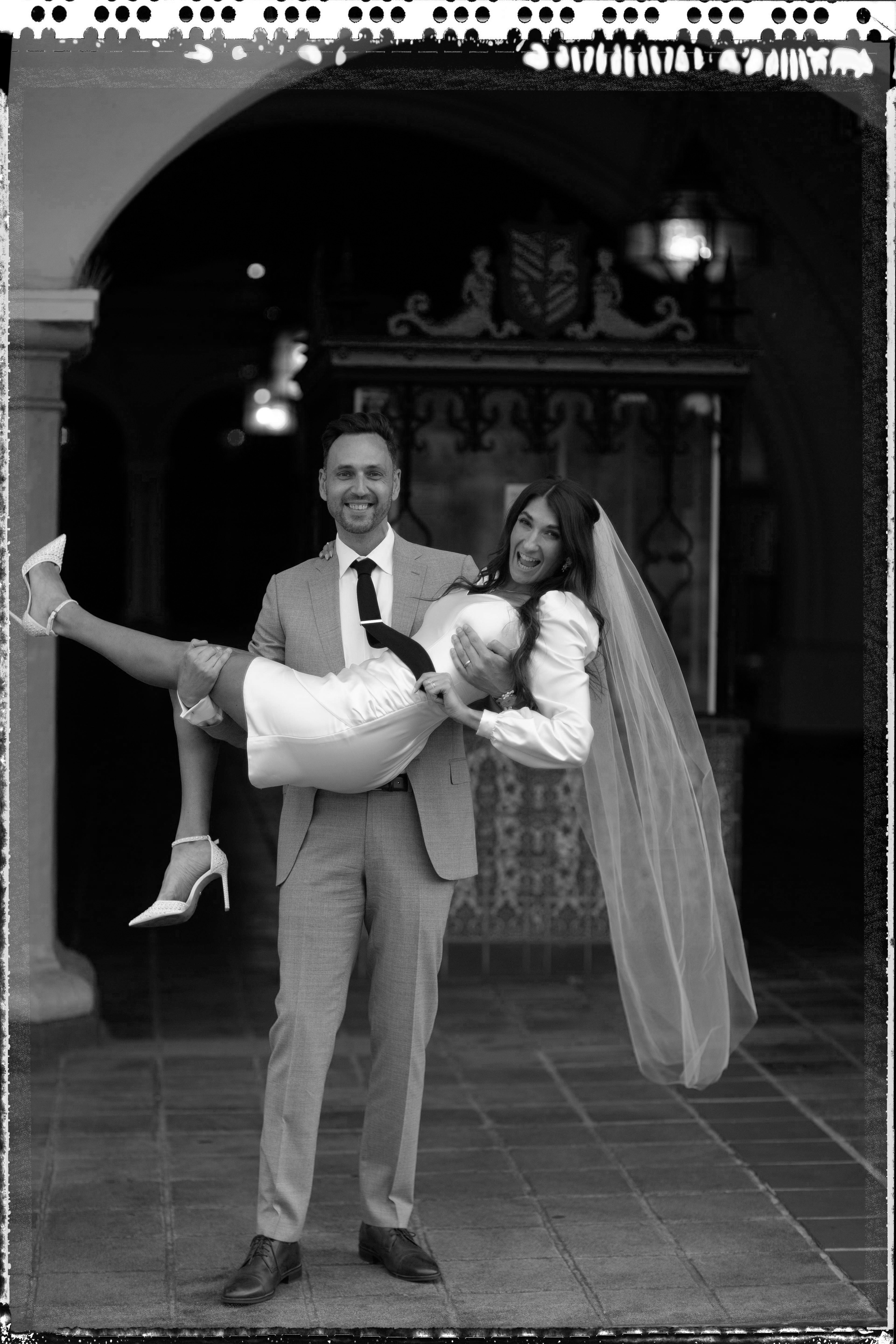 Newlyweds laughing together outside the Santa Barbara Courthouse