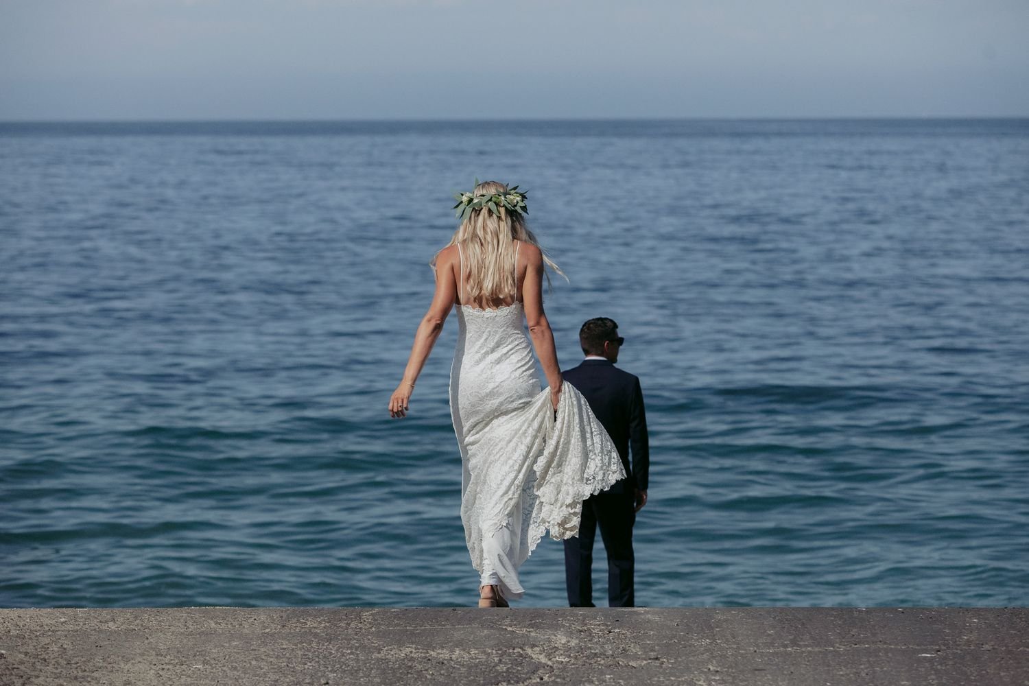 Newlyweds walking toward the ocean after an elopement