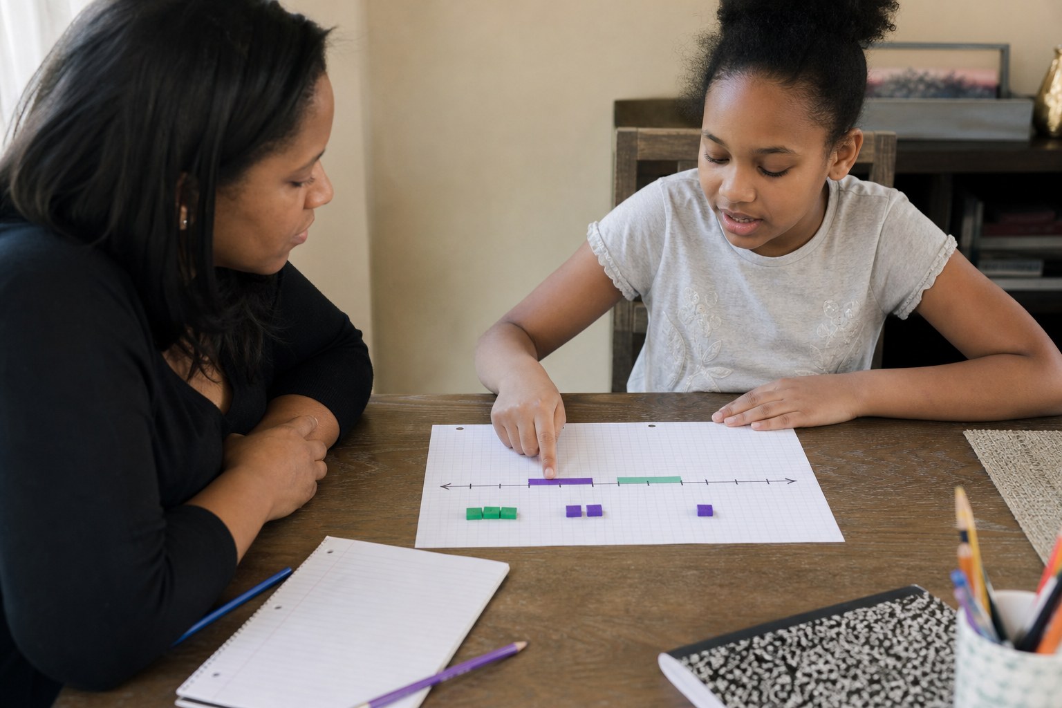 Learner explaining a number line to a parent or guardian at a home table