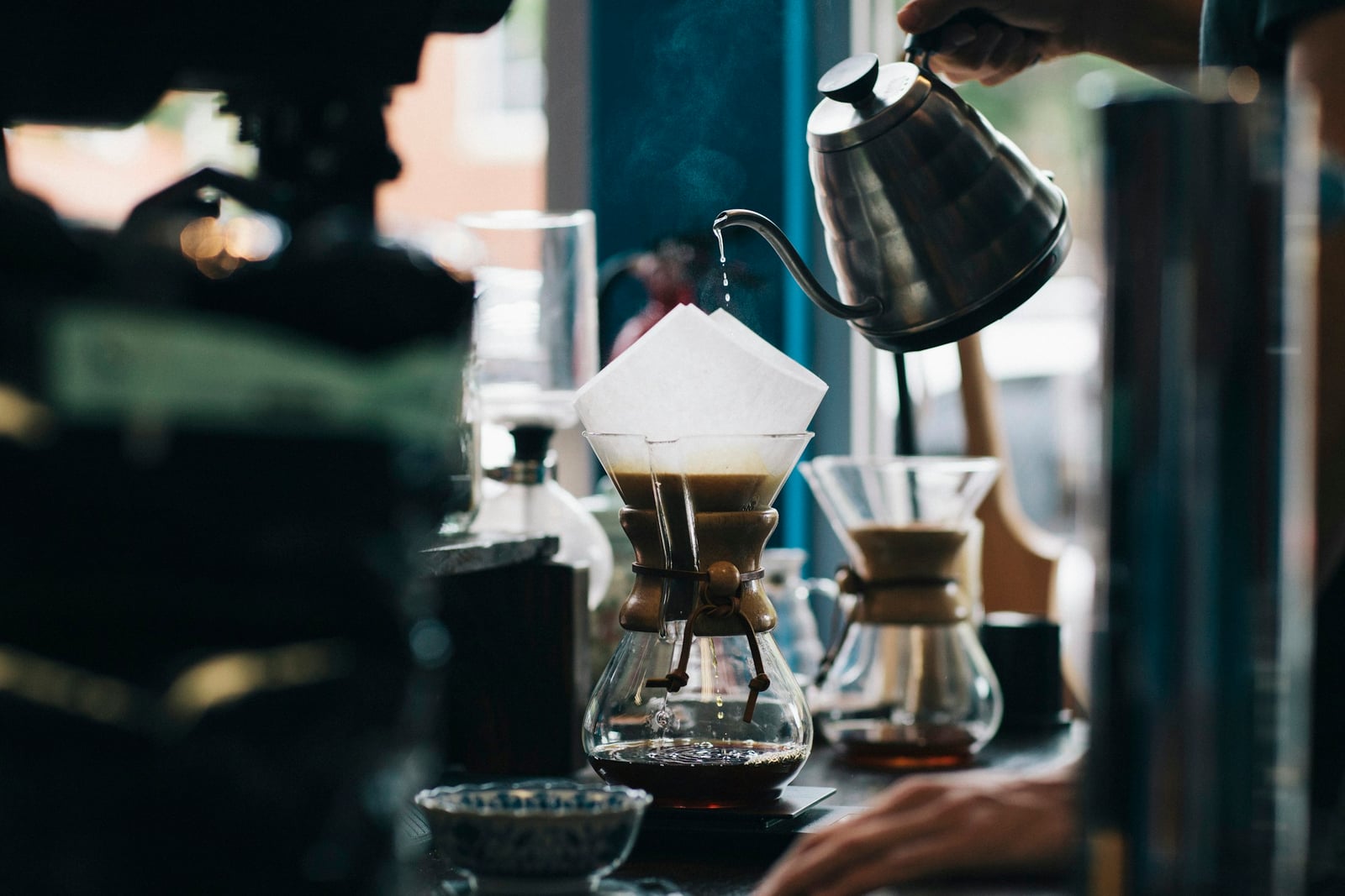 Pour-over coffee brewing through a paper filter into a glass carafe