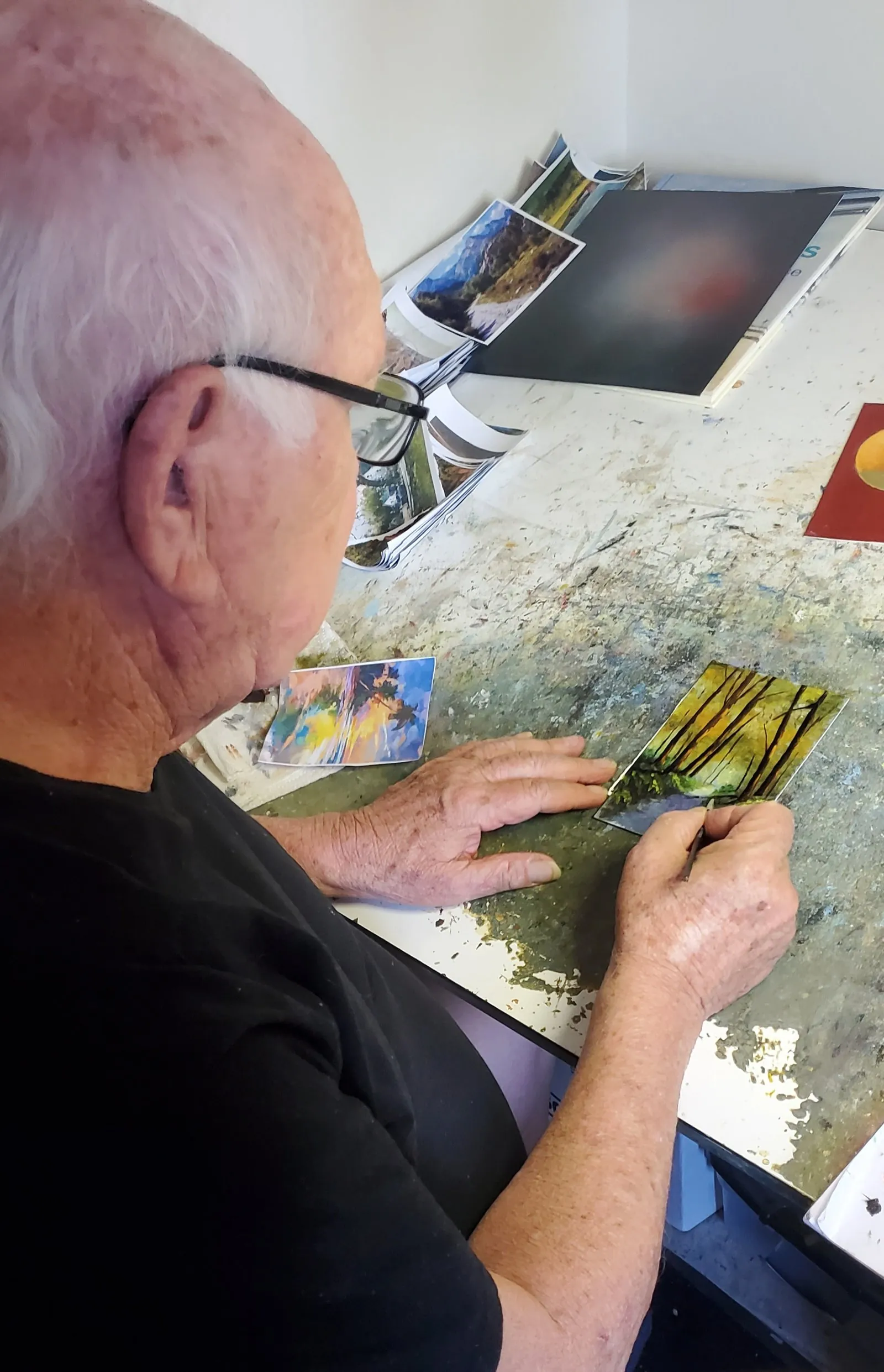 Fred Wilson painting a miniature artwork at his studio table