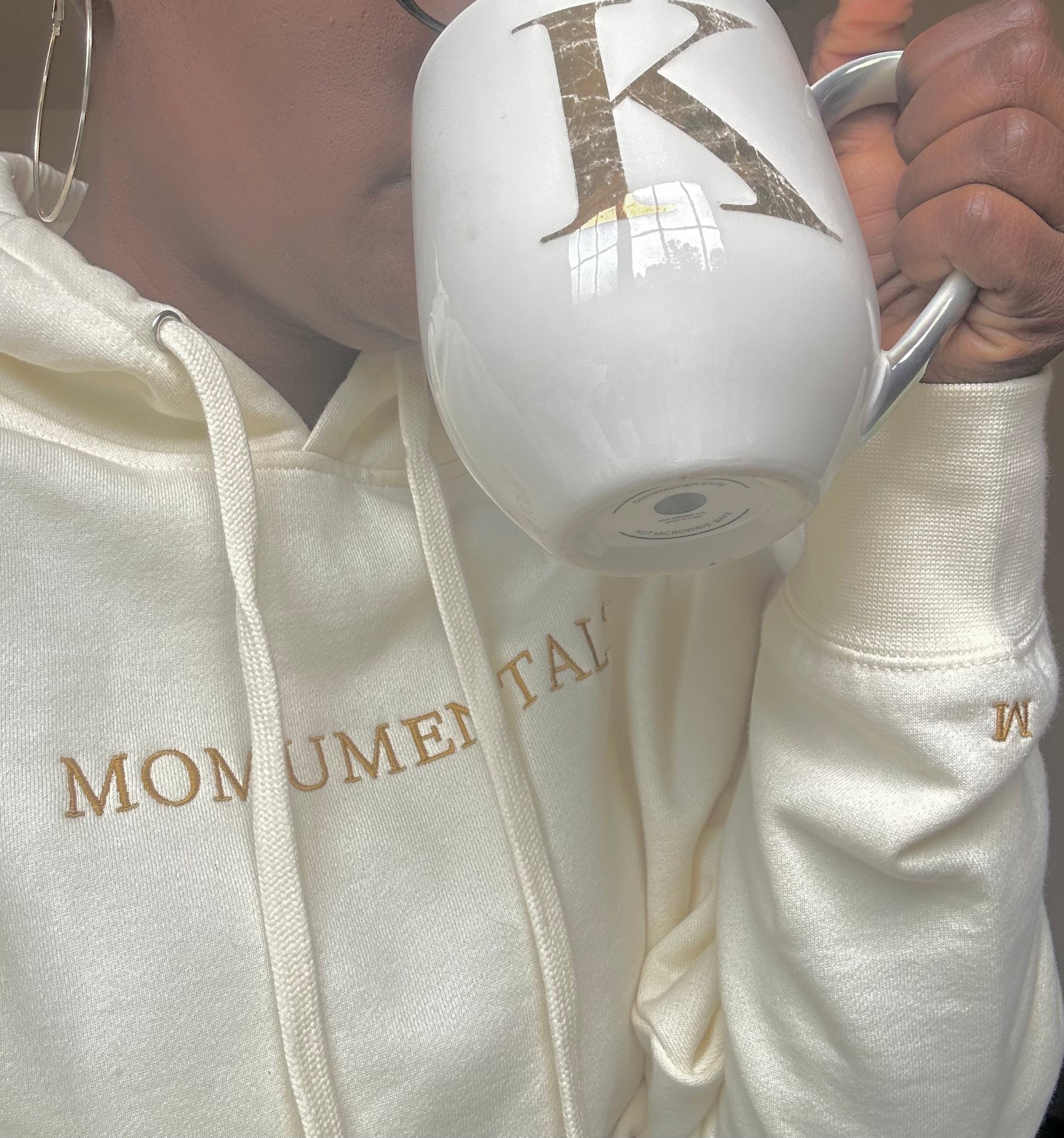 Momumental hoodie beside a warm drink