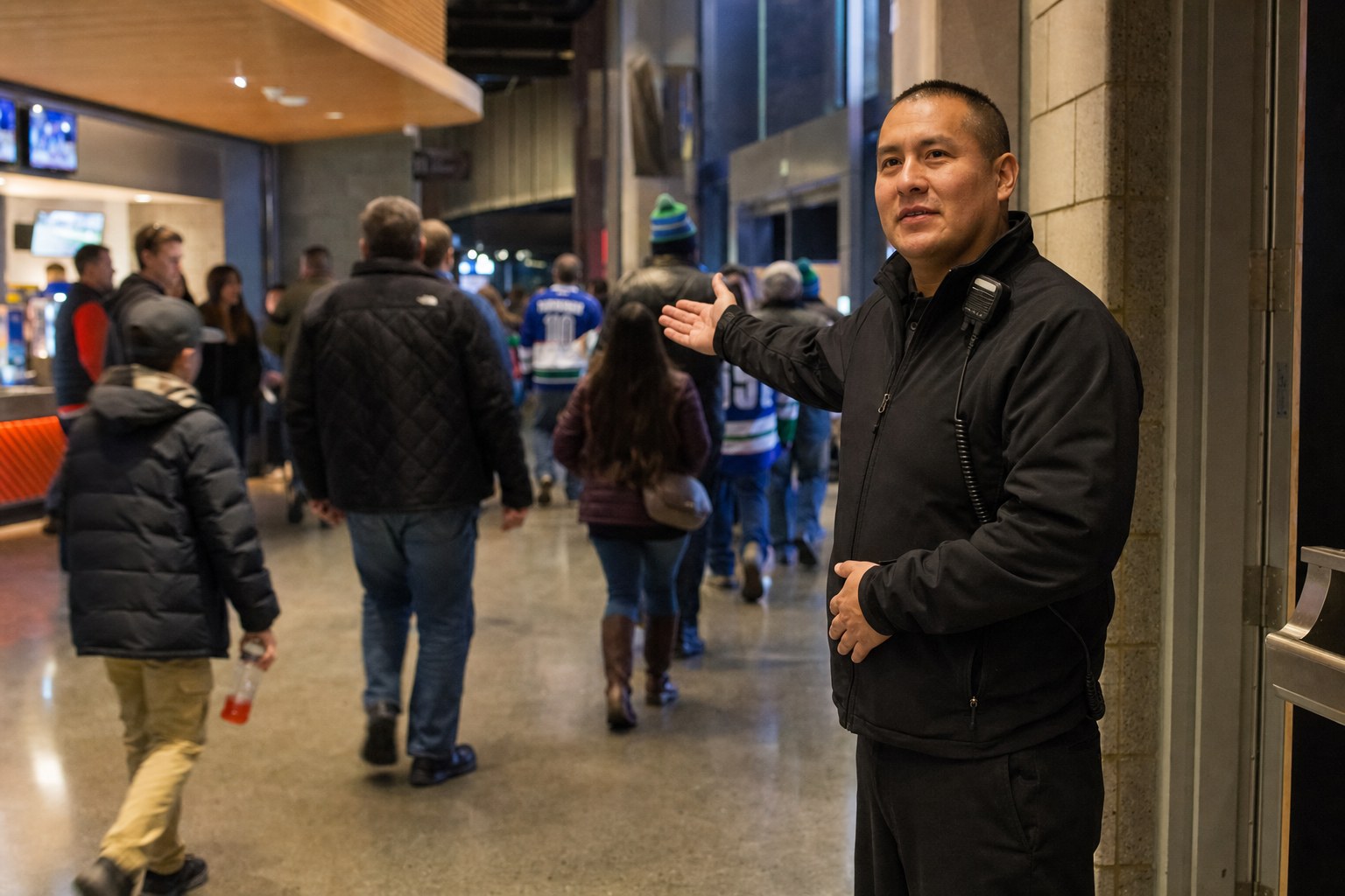 Security staff member helping guests find their way in an arena concourse