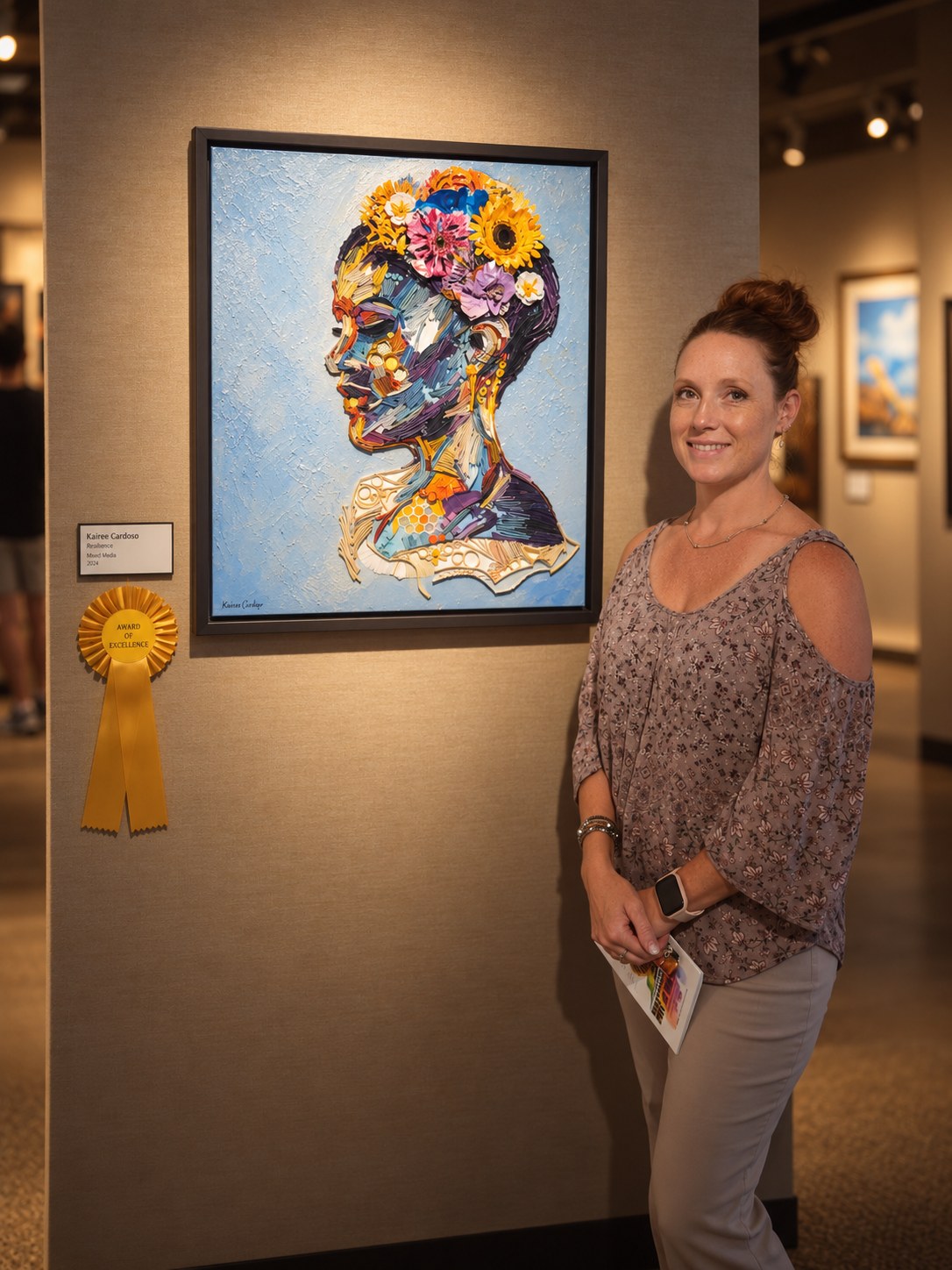 Kairee Cardoso beside her artwork at a gallery exhibition