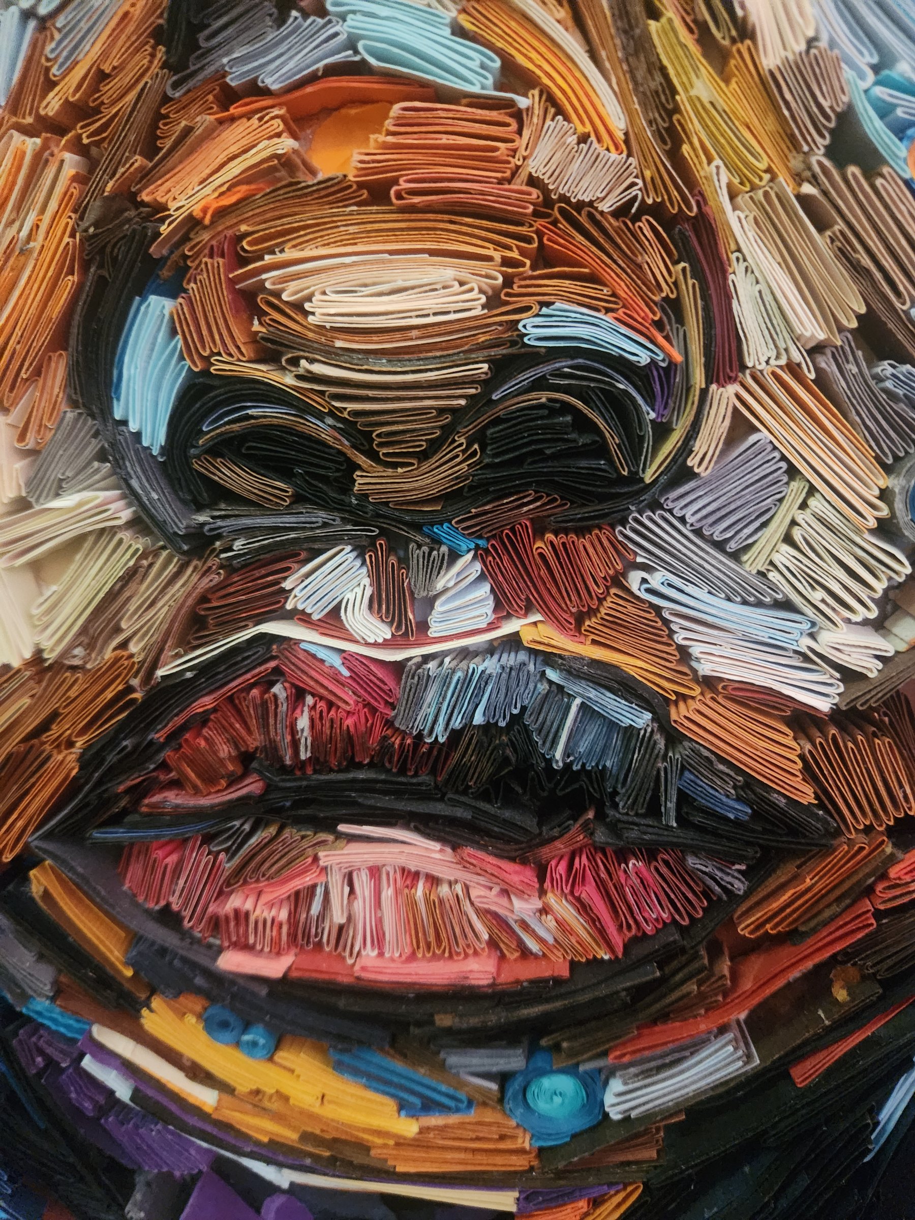 Close-up of folded and layered paper forming a handmade portrait