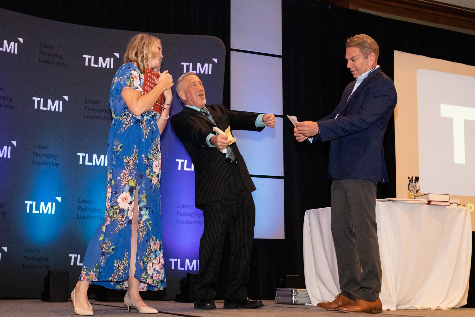 boB performing on stage with two guests at a corporate event