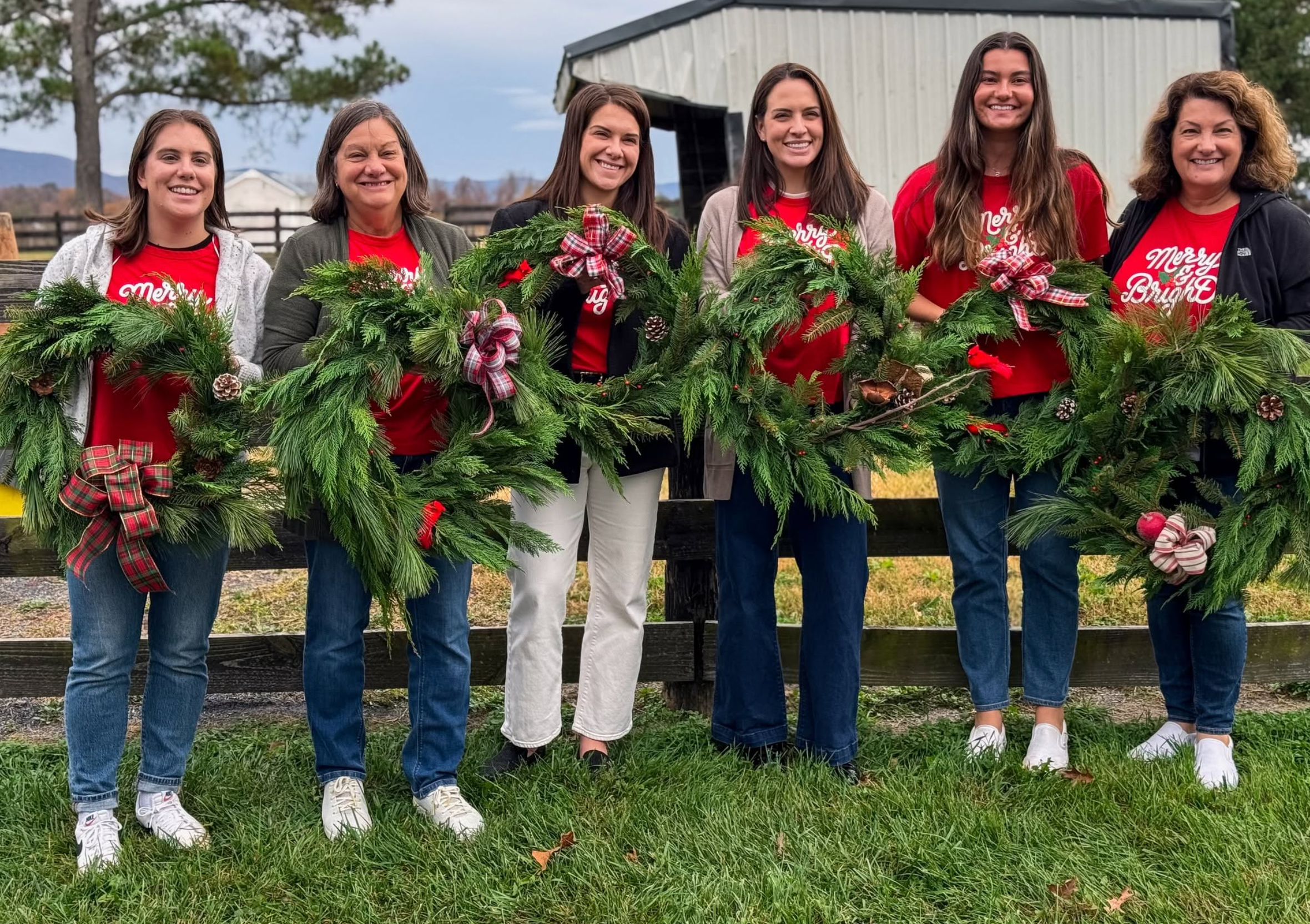 Holiday Wreath Making Workshop participants holding wreaths