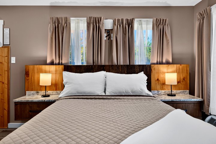 Blackrock Vista · Loft 201: Bed framed by windows and reading lamps