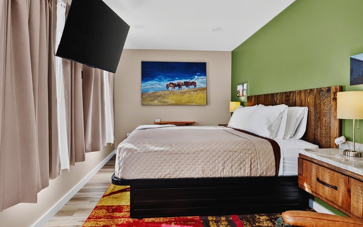 Pine Top · Loft 203: Bedroom with green accent wall and horse artwork