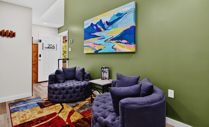 Shenandoah Skies · Loft 204: Purple armchairs beneath mountain artwork
