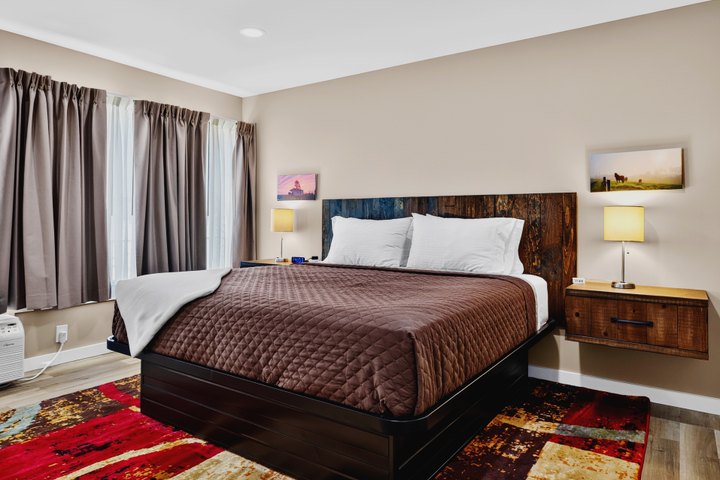 Shenandoah Skies · Loft 204: Bedroom with wooden headboard and colorful rug