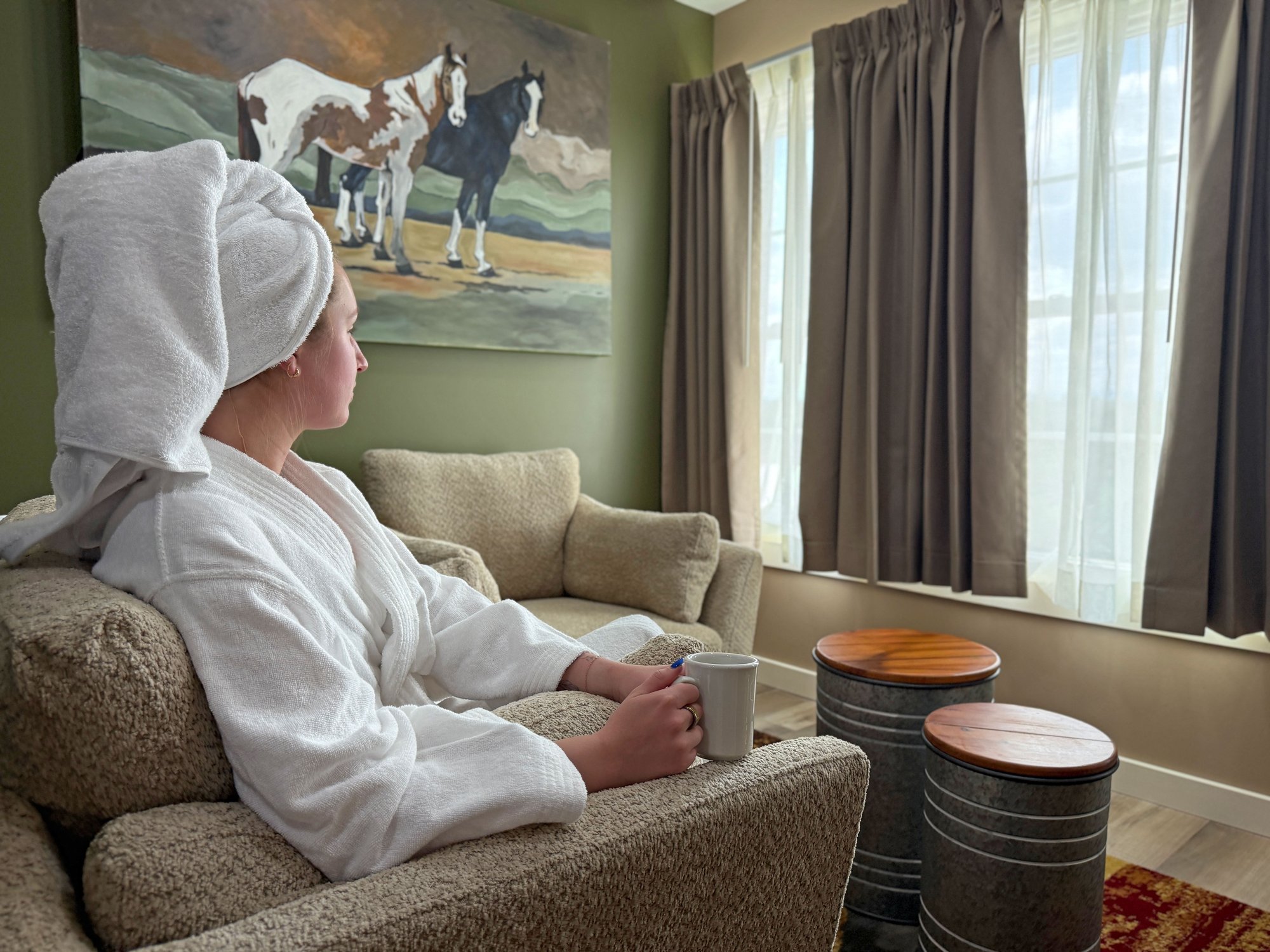 Guest relaxing with a warm drink in a Stable Craft overnight suite