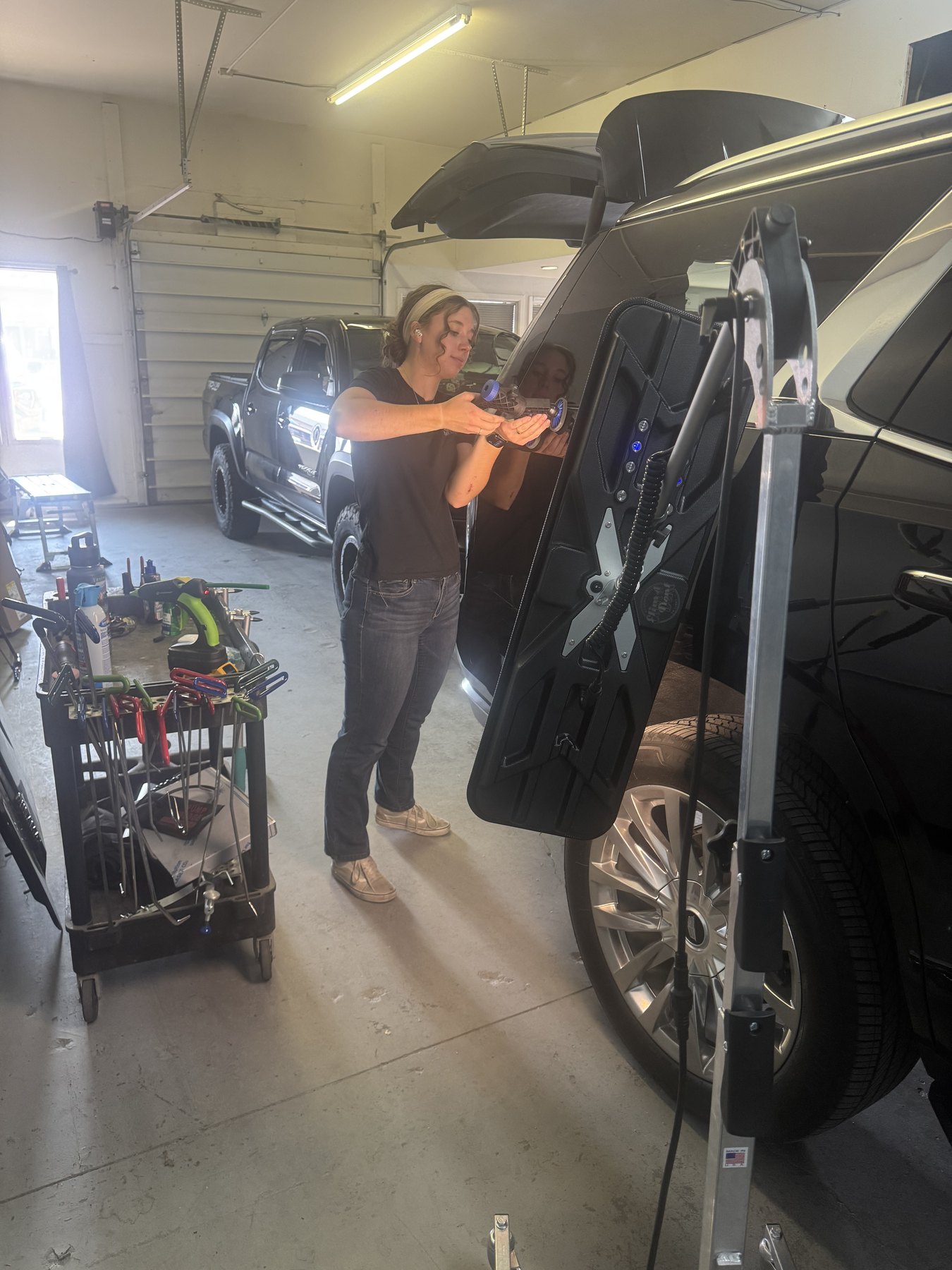 Auto Hail Zone technician repairing a vehicle door with paintless dent repair tools