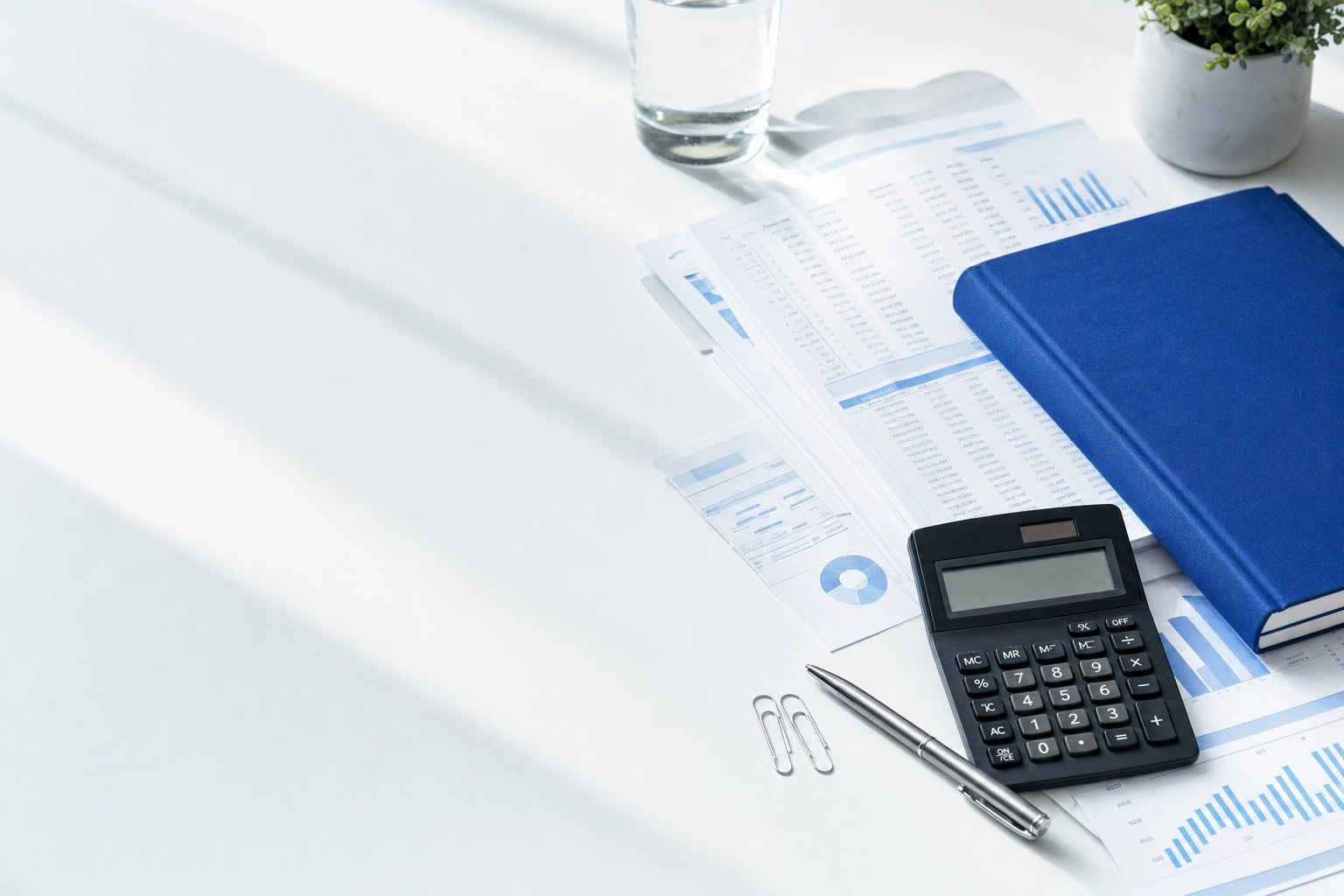 Organized financial documents, blue ledger and calculator on a desk