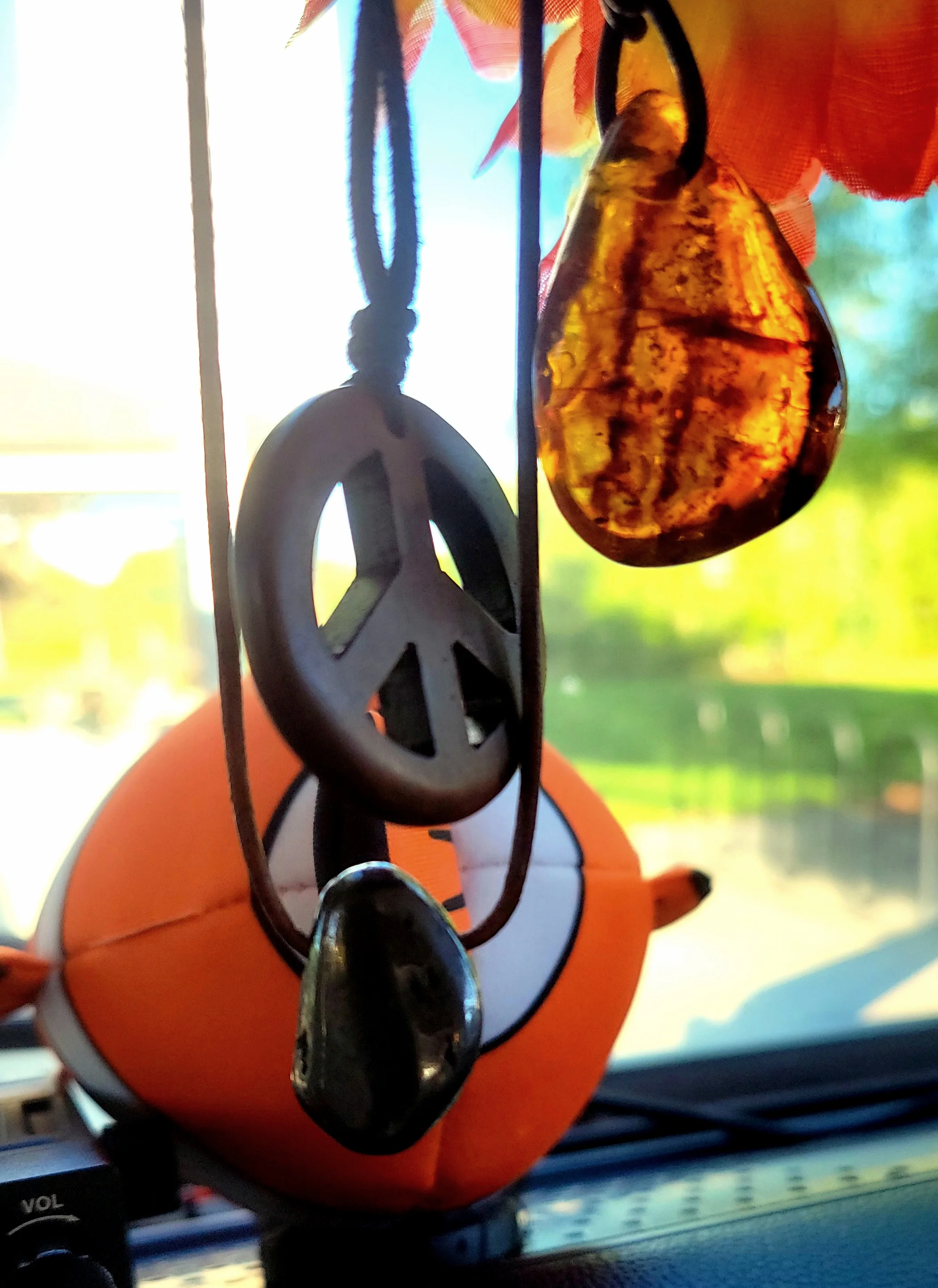 Peace sign and amber charm hanging inside Kaspar, a 1970 Volkswagen Westfalia