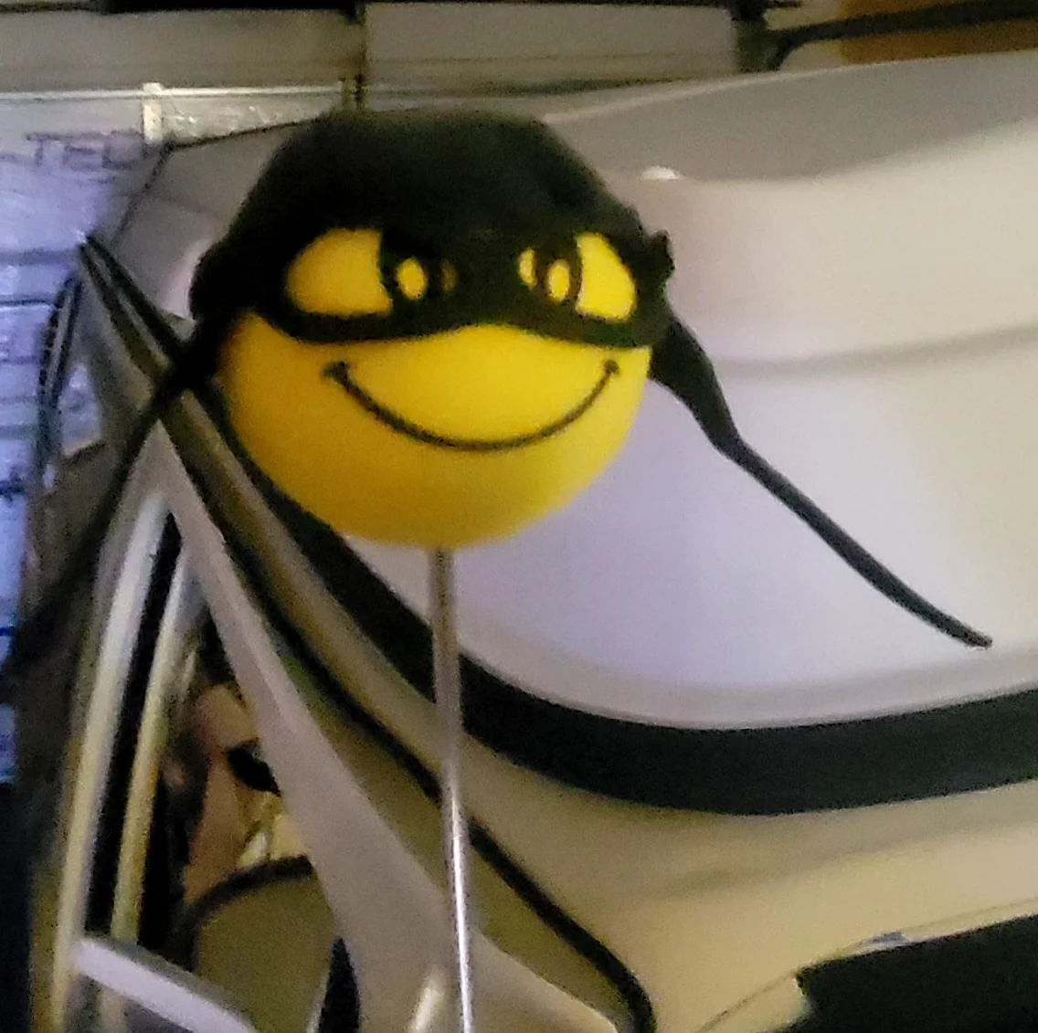 A smiling yellow character wearing sunglasses beside Kaspar