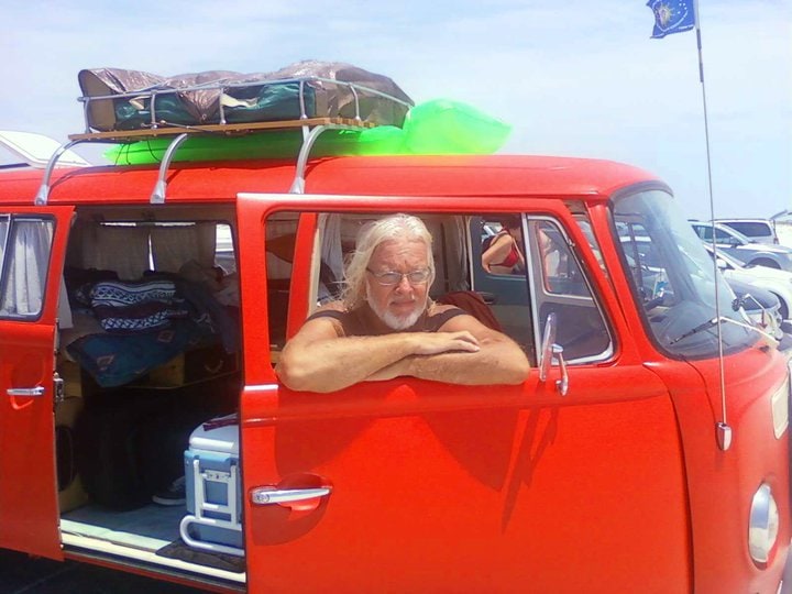 G.J. Dürrschmidt leaning from Vinnie van Go, a red Volkswagen love bus